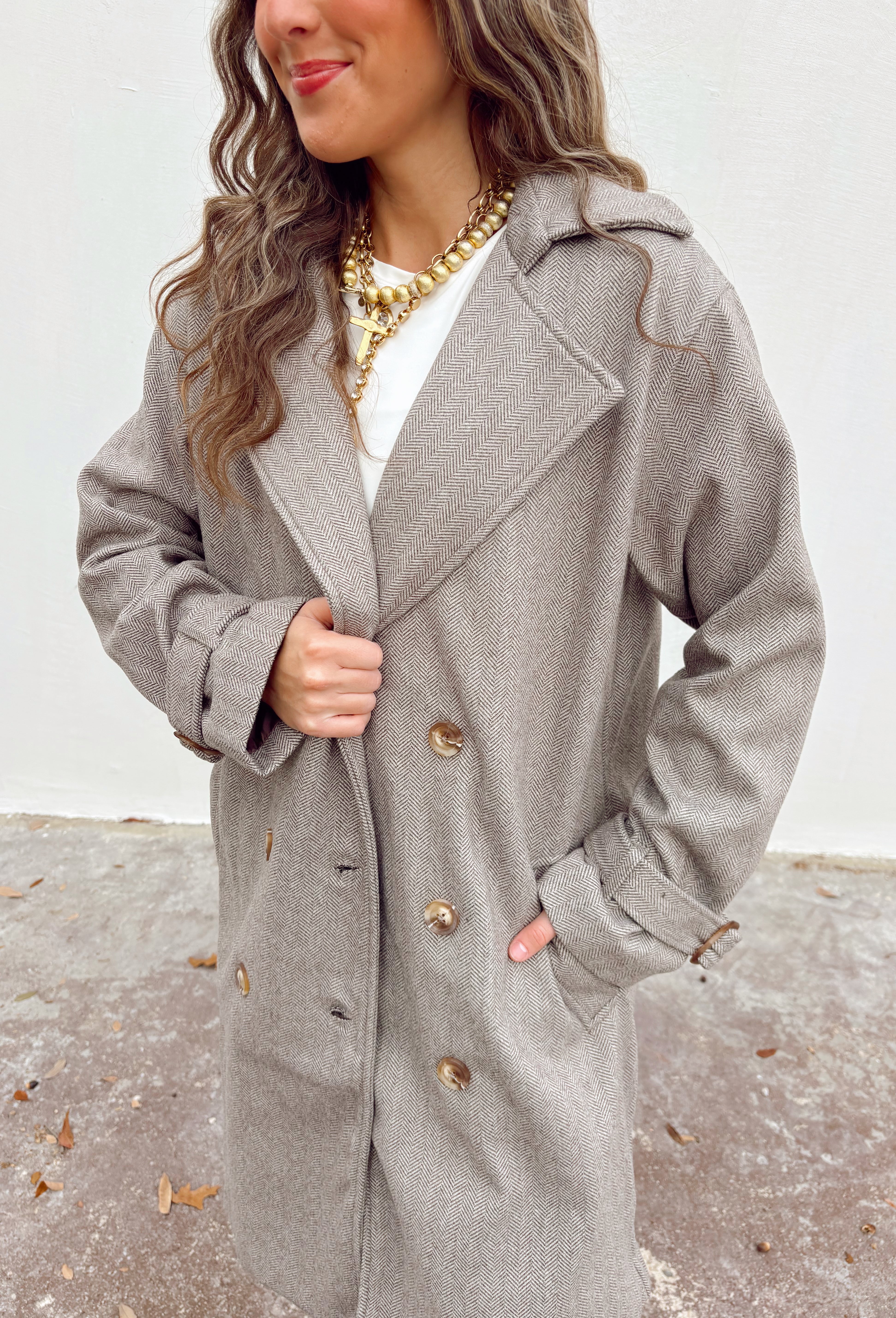 Timeless and tailored, this brown mini houndstooth coat by Haute Monde is a must-have for the chilly season. Featuring a collared neckline and button-down front, this soft and cozy coat brings effortless polish to any winter look. Its classic pattern and warm, textured feel make it a go-to piece for layering over sweaters, dresses, or denim all season long.