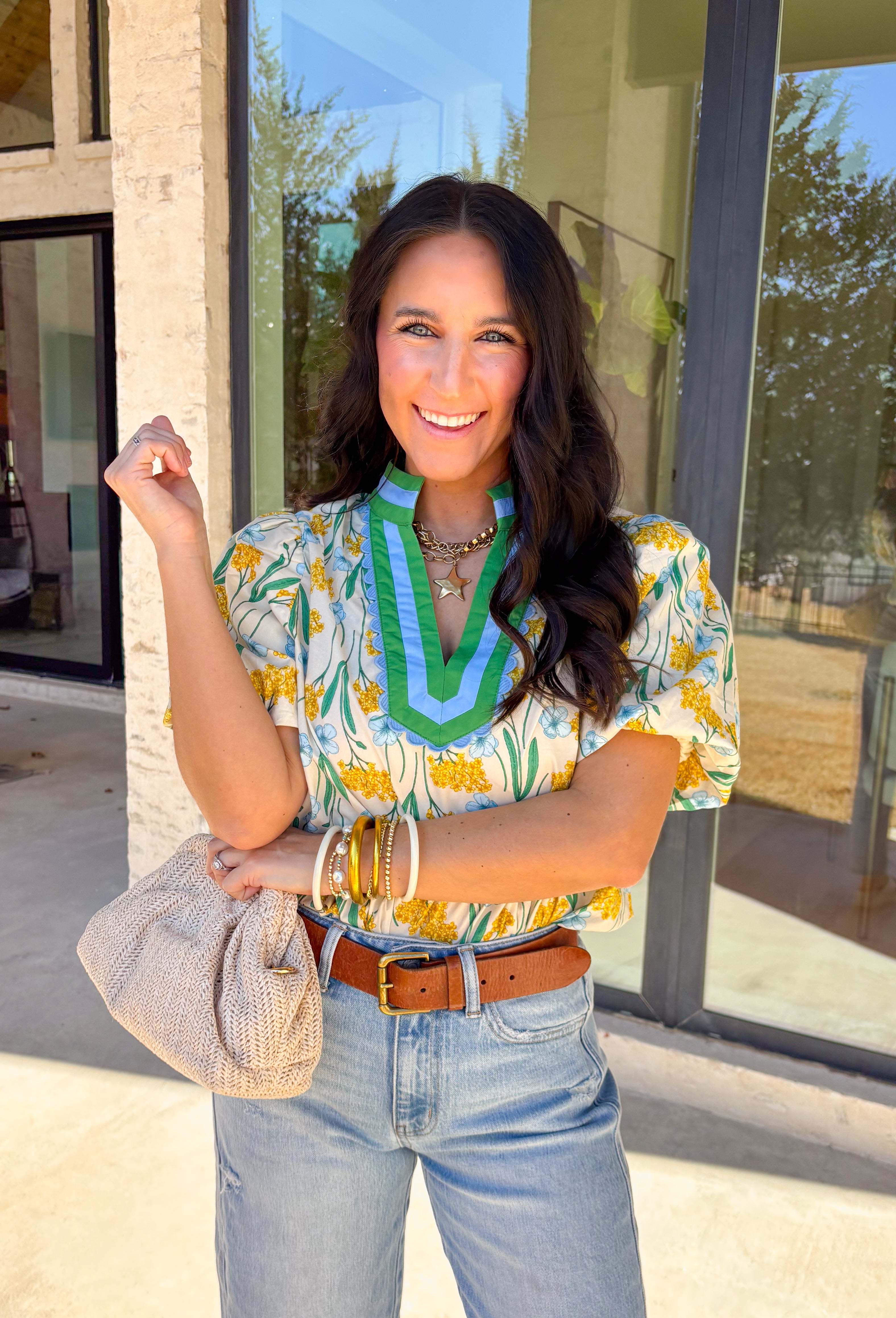 Bright, happy, and made for spring days, this cream short sleeve top by Entro is full of charming details. Featuring a colorful floral print with pops of yellow, blue, and green, it brings an easy burst of color to your look. The green and blue trim along the top adds contrast, while the blue scalloped trim gives it a sweet, polished finish. Puff sleeves complete the look with a soft, feminine touch, making this top perfect for sunny days ahead.