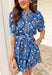 Fresh, fun, and full of spring charm, this blue short sleeve button-down dress by Entro is an easy standout. Featuring a floral print throughout, it brings the perfect pop of color while still feeling effortless and wearable. Blue and white striped trim accents the design for a playful contrast, and the matching self-tie waist gives it a flattering, adjustable fit. Finished with side pockets and a fully lined cotton feel, this dress is perfect for brunch, spring events, and sunny weekends.