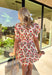 Fresh, fun, and full of spring charm, this cream short sleeve button-down dress by Entro is an easy standout. Featuring a red floral print throughout, it brings the perfect pop of color while still feeling effortless and wearable. Red and white striped trim accents the design for a playful contrast, and the matching self-tie waist gives it a flattering, adjustable fit. Finished with side pockets and a fully lined cotton feel, this dress is perfect for brunch, spring events, and sunny weekends.