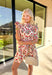 Fresh, fun, and full of spring charm, this cream short sleeve button-down dress by Entro is an easy standout. Featuring a red floral print throughout, it brings the perfect pop of color while still feeling effortless and wearable. Red and white striped trim accents the design for a playful contrast, and the matching self-tie waist gives it a flattering, adjustable fit. Finished with side pockets and a fully lined cotton feel, this dress is perfect for brunch, spring events, and sunny weekends.