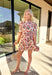 Fresh, fun, and full of spring charm, this cream short sleeve button-down dress by Entro is an easy standout. Featuring a red floral print throughout, it brings the perfect pop of color while still feeling effortless and wearable. Red and white striped trim accents the design for a playful contrast, and the matching self-tie waist gives it a flattering, adjustable fit. Finished with side pockets and a fully lined cotton feel, this dress is perfect for brunch, spring events, and sunny weekends.
