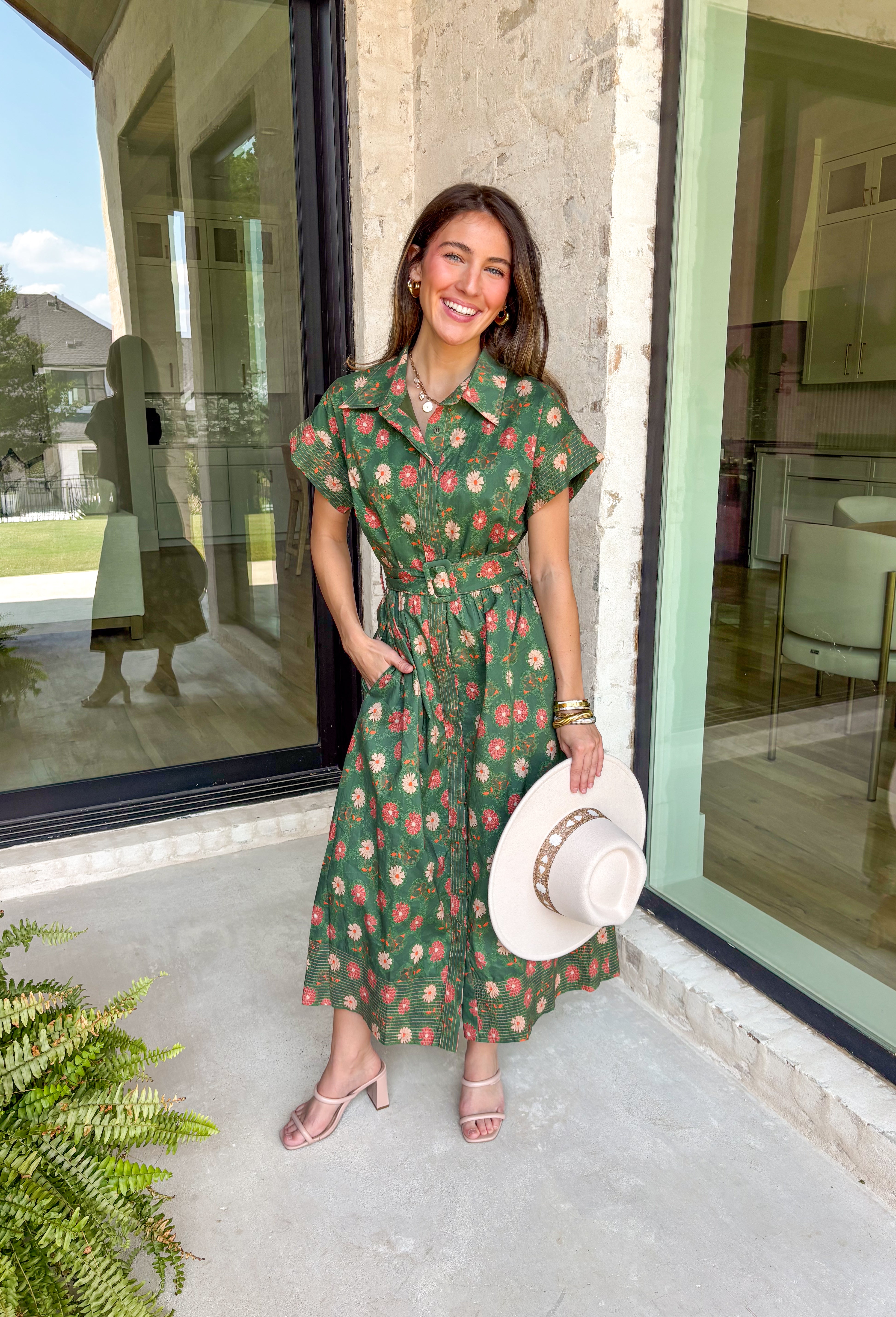 Brighten up your fall wardrobe with this dreamy green midi dress, splashed with warm shades of orange floral print. The collared neckline and button-down design add a touch of tailored charm, while the matching belt lets you cinch the waist for a flattering silhouette. Whether you're headed to brunch or a pumpkin patch date, this one’s got that perfect for all season long.