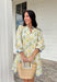 Fresh, cheerful, and made for spring days, this off-white dress by Entro is full of easy charm. Featuring a blue and yellow botanical floral print, it feels bright and breezy for the season. The split neckline adds a flattering touch, while the 3/4 puff sleeves bring soft volume. Scallop accent trim at the cuffs and hem gives it extra detail, and side pockets (because we love a functional moment) make it just as practical as it is pretty. 