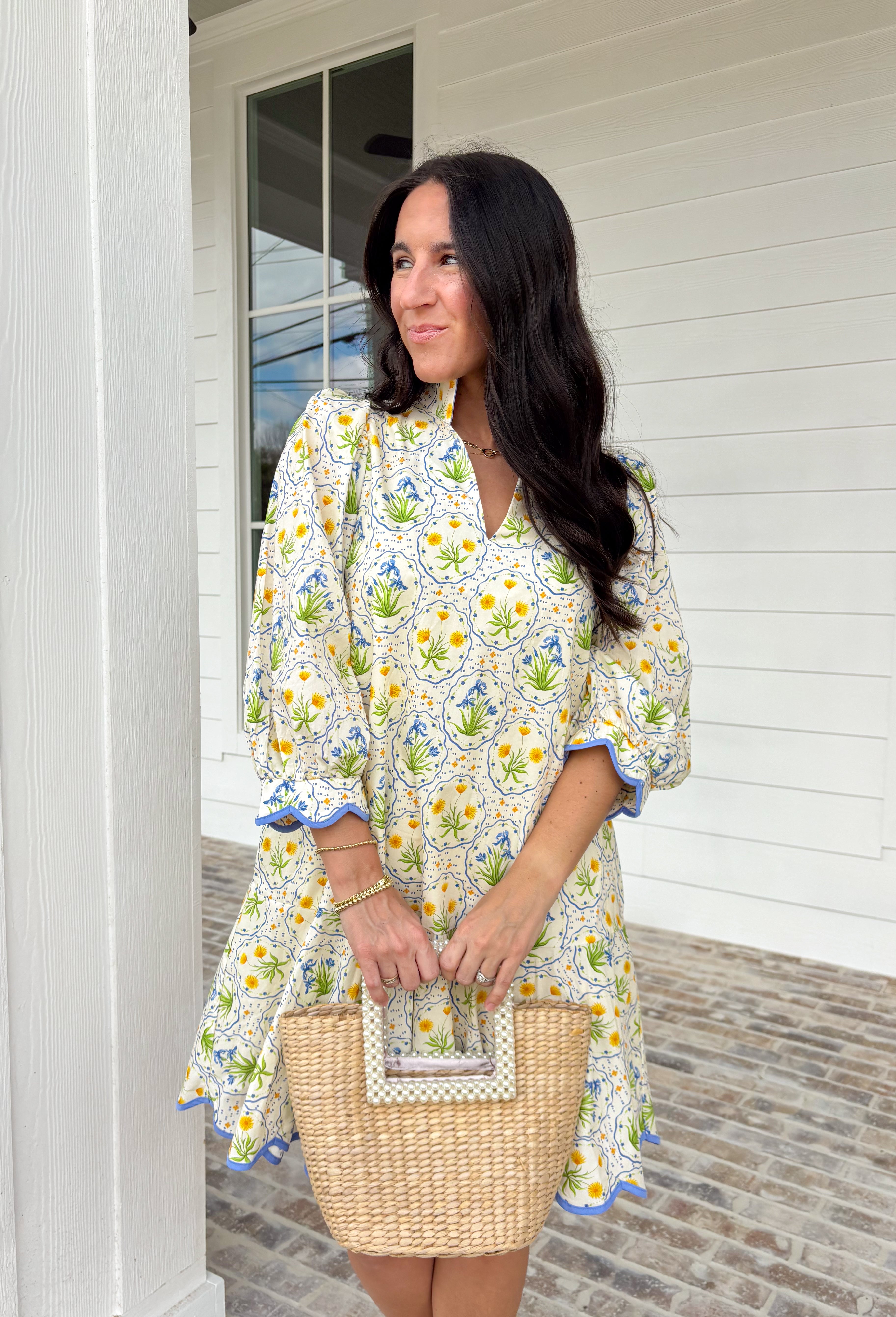 Fresh, cheerful, and made for spring days, this off-white dress by Entro is full of easy charm. Featuring a blue and yellow botanical floral print, it feels bright and breezy for the season. The split neckline adds a flattering touch, while the 3/4 puff sleeves bring soft volume. Scallop accent trim at the cuffs and hem gives it extra detail, and side pockets (because we love a functional moment) make it just as practical as it is pretty. 