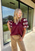 A rich autumn hue and elegant details make this burgundy top a seasonal standout. The v-neck band collar frames the neckline beautifully, while the embroidered placket adds a refined, textural touch. Short bubble sleeves bring a playful element to the silhouette, and the soft cotton-blend fabric keeps it comfortable from work to weekend. It’s the perfect piece to pair with denim, trousers, or skirts for a versatile fall look.