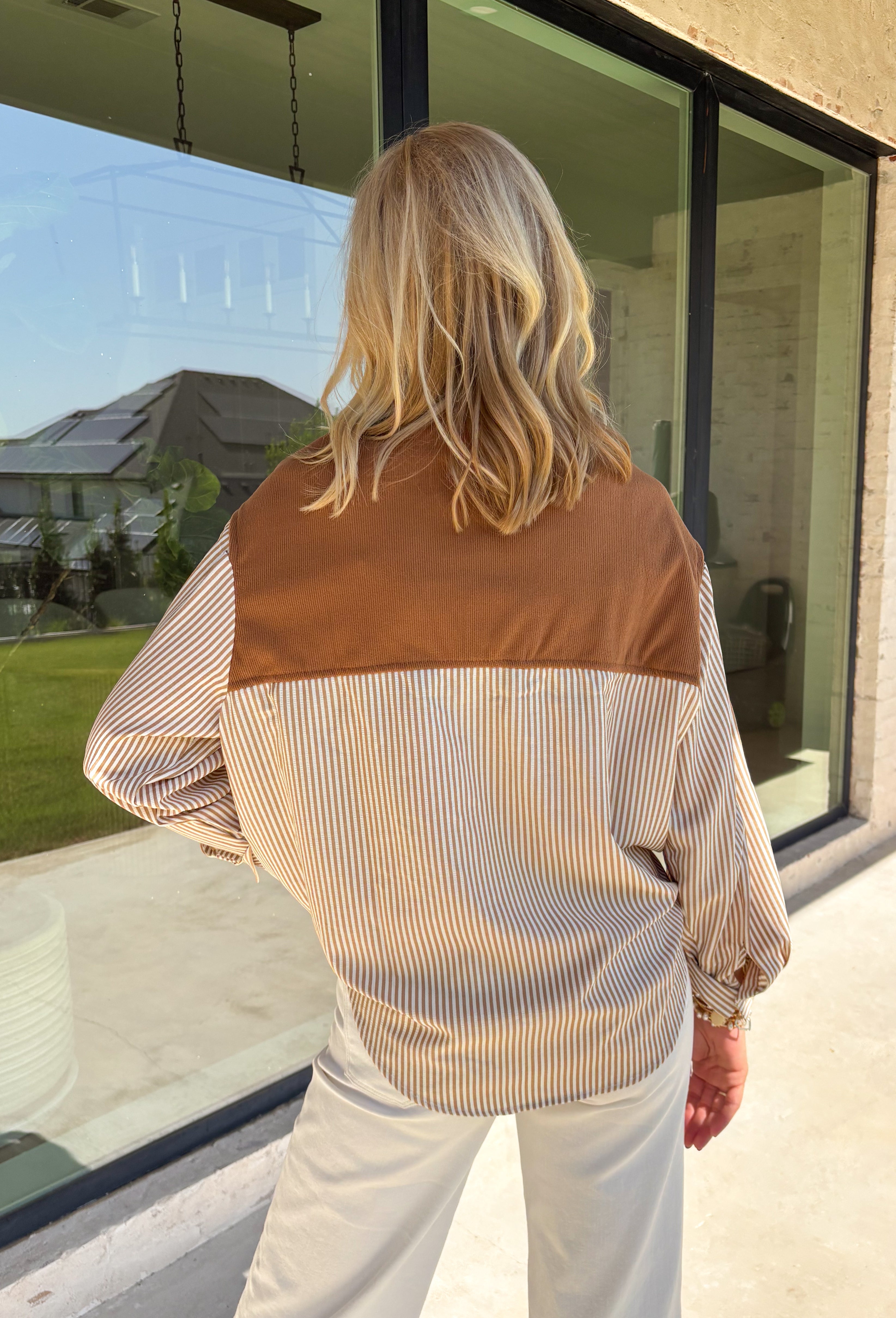 Get the polished look of layering without any extra effort in this chic top from Hyfve. Designed with a classic camel and white striped button-down base, this unique piece features a camel ribbed sweater overlay for a perfectly styled layered look in one easy top. The collared neckline and front pocket add timeless appeal, while the lightweight fabric keeps it comfortable for all-day wear. 