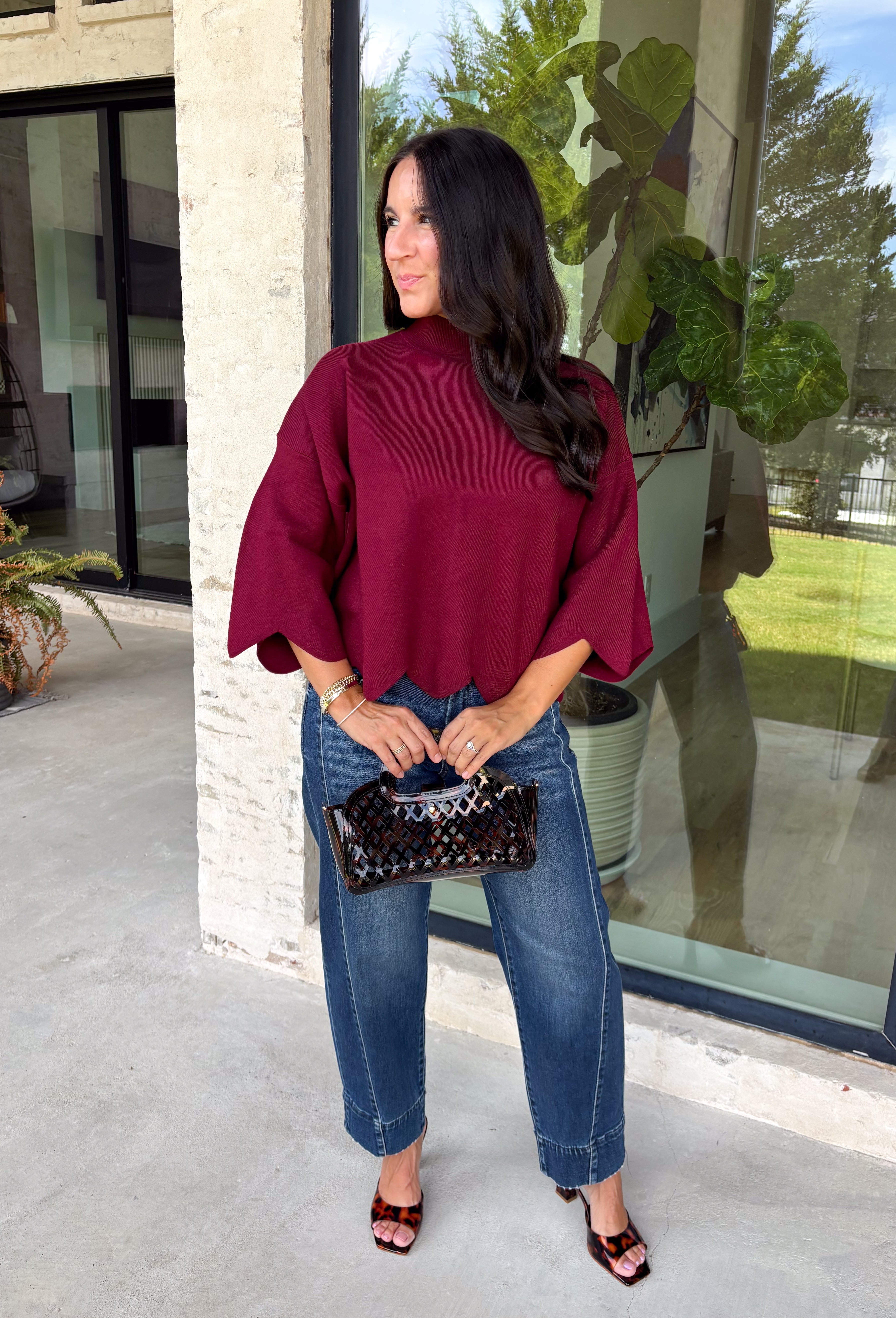 Rich merlot color makes this sweater top from Entro an instant favorite for the cooler months. The deep wine-inspired shade adds the perfect pop of seasonal color while still pairing easily with denim, cream, camel, and other autumn neutrals. A mock neckline gives it a classic look, while scalloped edges along the hem and sleeves add a sweet, unexpected finish. The ¾ length sleeves make it an easy transitional piece for warmer fall afternoons and chilly days ahead. 