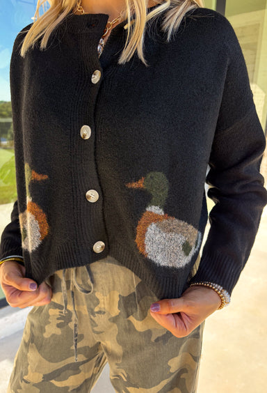 A cardigan with character—this black knit sweater is anything but ordinary. Designed with a button-down front, it’s accented with two charming ducks on the front that bring a whimsical, playful twist to your fall wardrobe. The soft knit blend offers warmth and comfort, while the relaxed fit makes it perfect for layering over everything from tees to dresses. A fun conversation starter that still feels cozy enough for everyday wear.