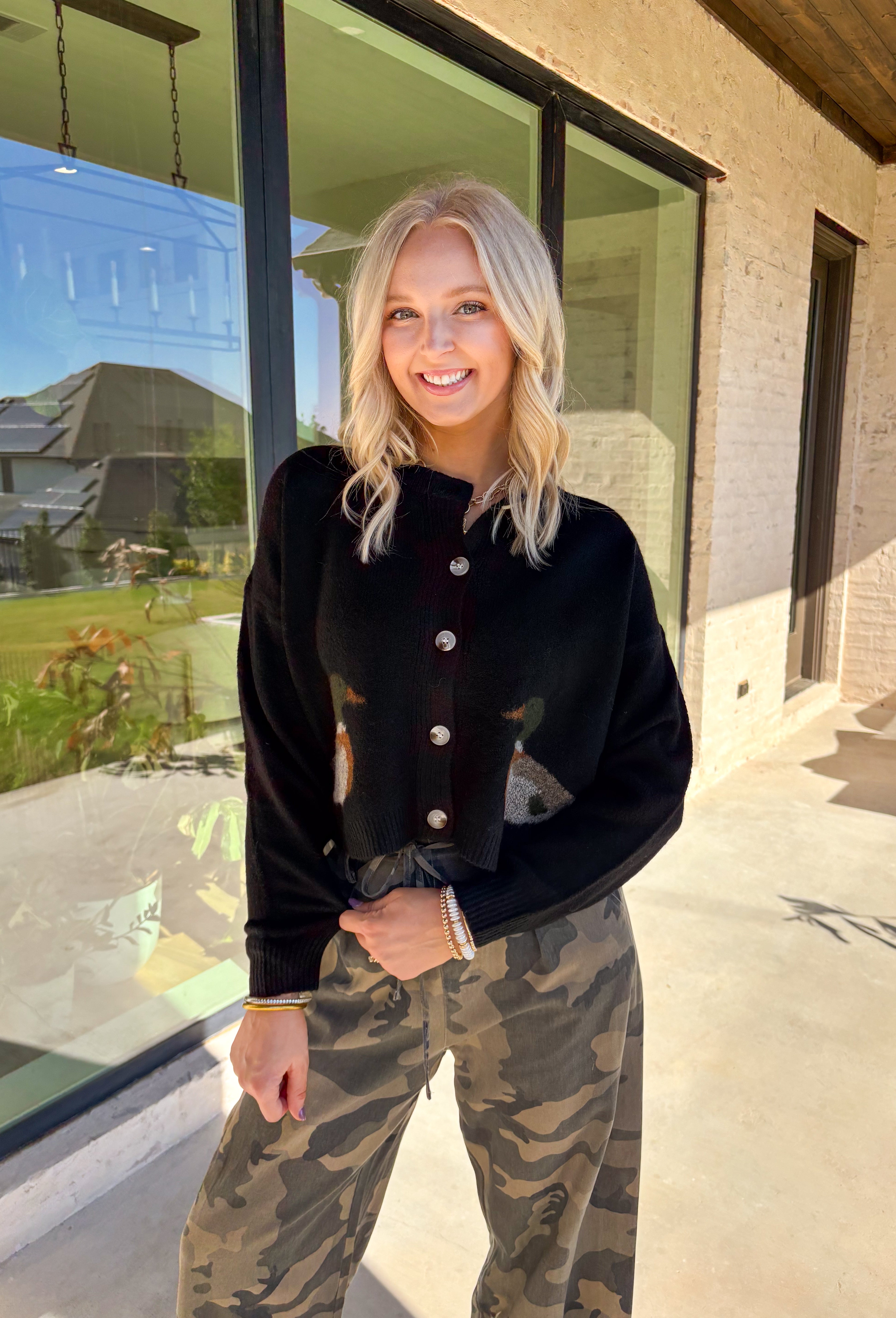 A cardigan with character—this black knit sweater is anything but ordinary. Designed with a button-down front, it’s accented with two charming ducks on the front that bring a whimsical, playful twist to your fall wardrobe. The soft knit blend offers warmth and comfort, while the relaxed fit makes it perfect for layering over everything from tees to dresses. A fun conversation starter that still feels cozy enough for everyday wear.