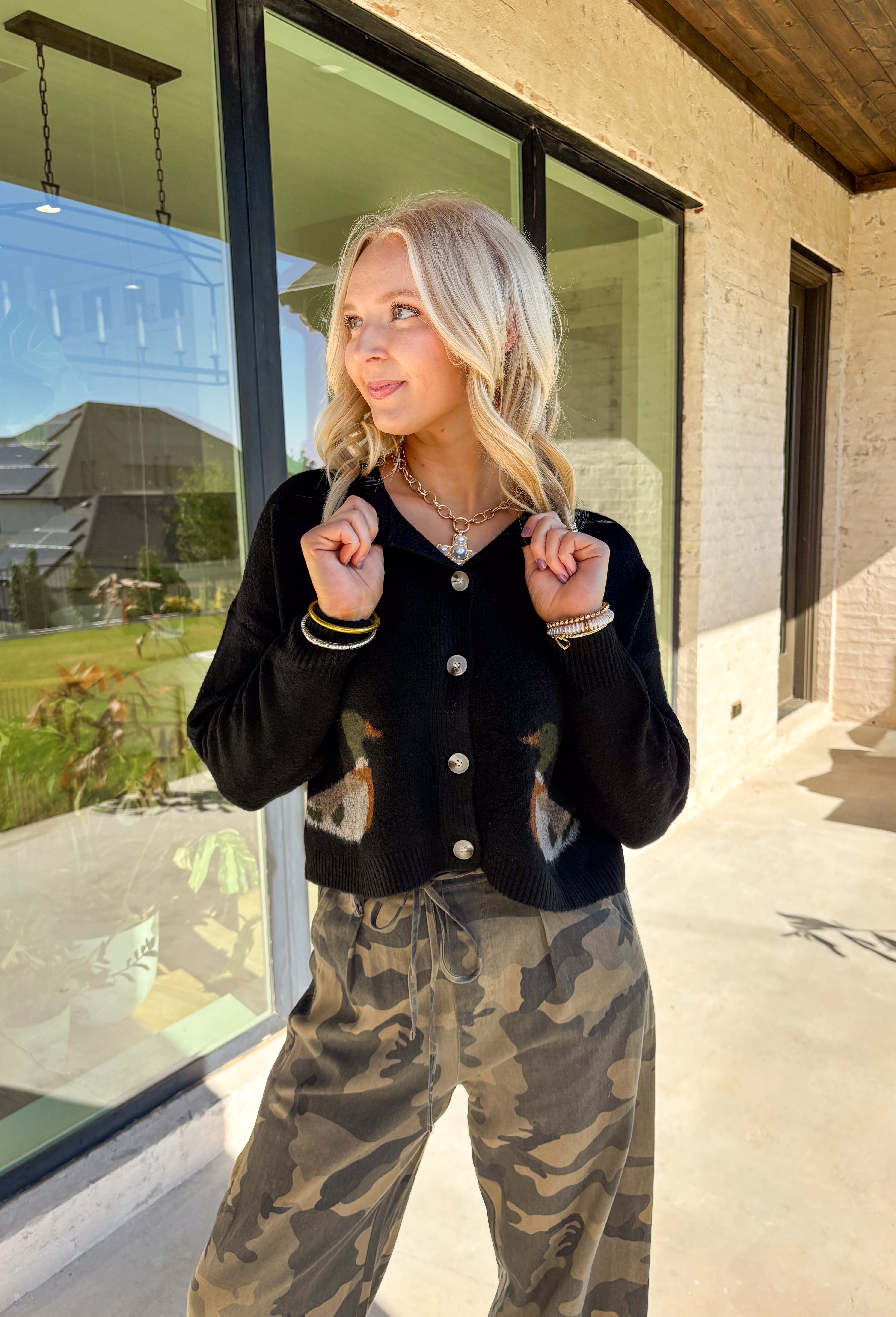 A cardigan with character—this black knit sweater is anything but ordinary. Designed with a button-down front, it’s accented with two charming ducks on the front that bring a whimsical, playful twist to your fall wardrobe. The soft knit blend offers warmth and comfort, while the relaxed fit makes it perfect for layering over everything from tees to dresses. A fun conversation starter that still feels cozy enough for everyday wear.