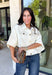 Meet the lightweight denim layer your wardrobe has been waiting for. This ecru short sleeve jacket from Entro gives classic denim a fresh update with a soft neutral shade and an easy draped silhouette. Snap buttons down the front keep the look casual, while chest pockets and additional front pockets add plenty of functional detail. Snap button closures at the sides give the design an unexpected finishing touch and add to its relaxed shape. 