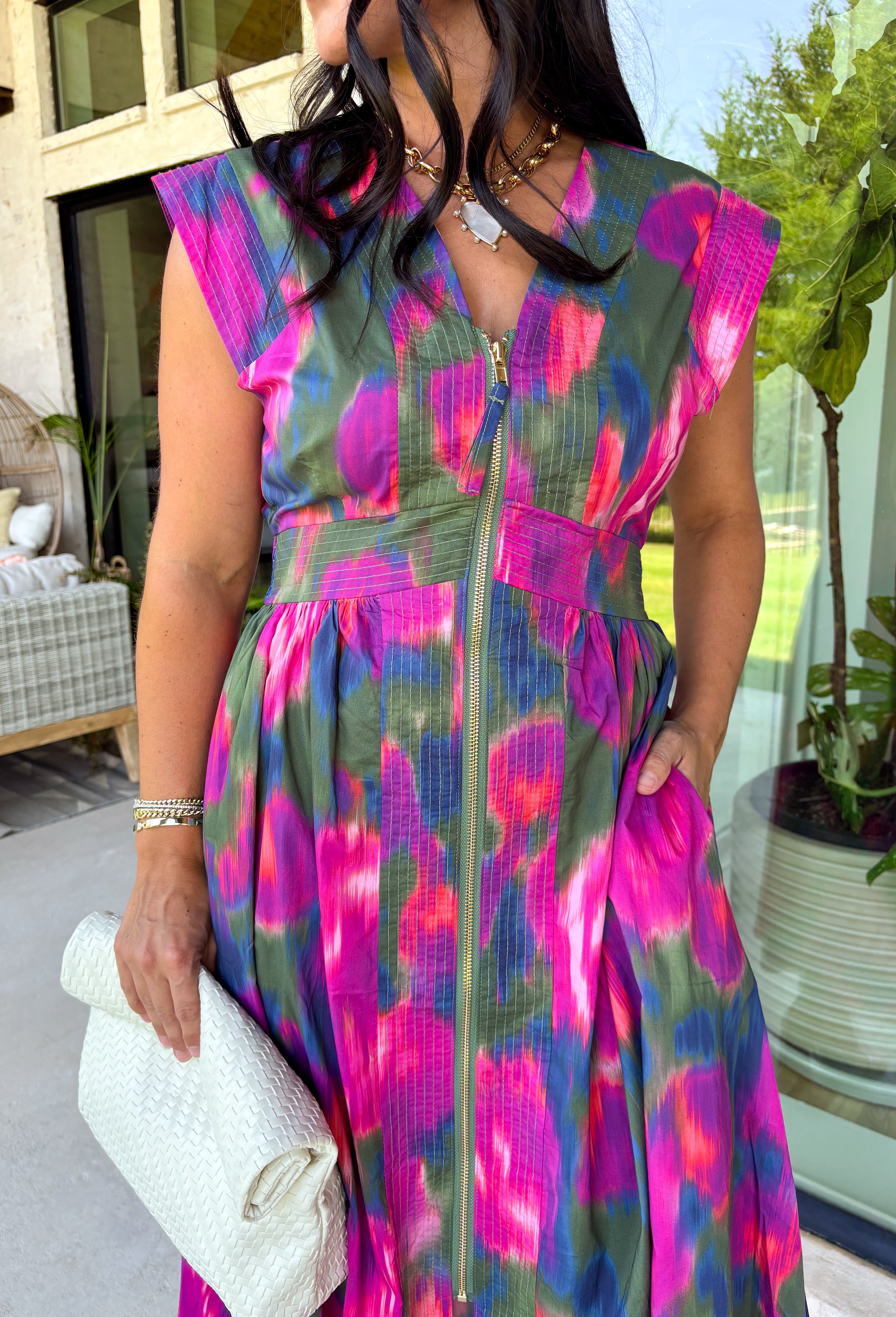 Bring a beautiful blend of color to your fall wardrobe with this eye-catching abstract print midi dress. Designed with a vibrant mix of autumn-inspired hues, this dress offers the perfect balance of playful style and timeless elegance. The flattering v-neckline is accented by a front zipper closure for a modern touch, while the defined waistband and smocked back waist create a comfortable, flattering fit. 