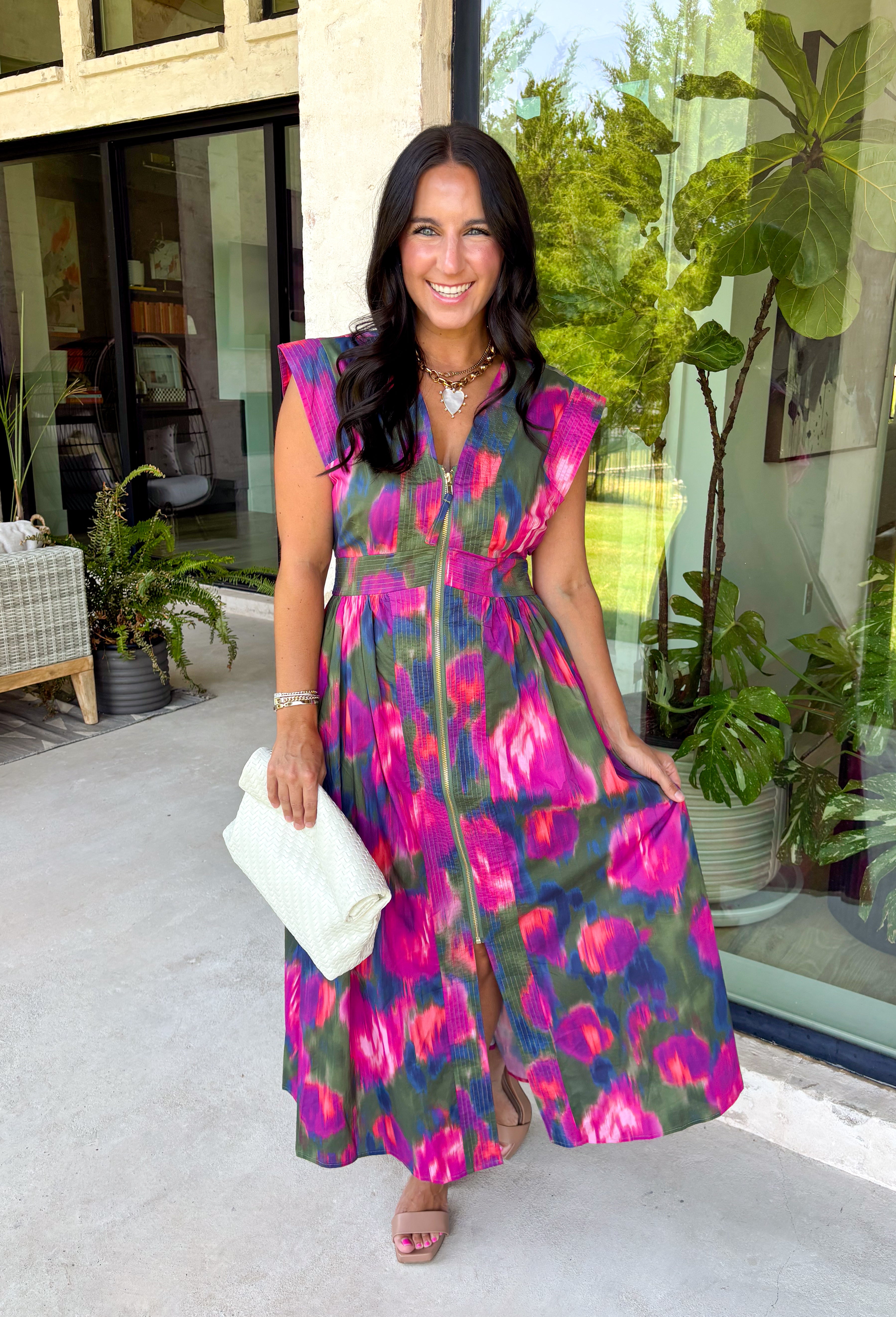 Bring a beautiful blend of color to your fall wardrobe with this eye-catching abstract print midi dress. Designed with a vibrant mix of autumn-inspired hues, this dress offers the perfect balance of playful style and timeless elegance. The flattering v-neckline is accented by a front zipper closure for a modern touch, while the defined waistband and smocked back waist create a comfortable, flattering fit. 