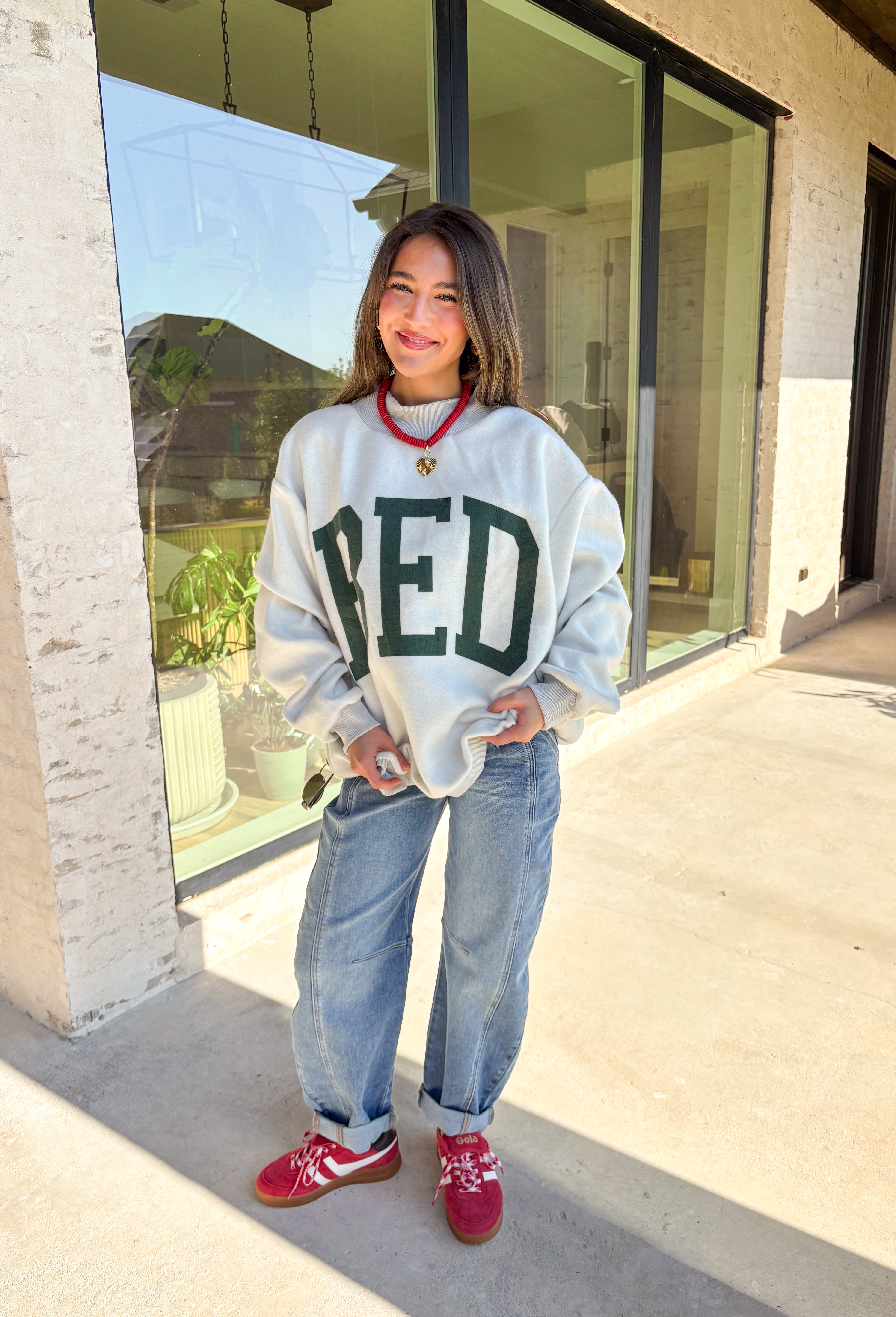 Two moods, one cozy pullover. This reversible mock neck sweater gives you options with light gray on one side and soft white fleece on the other. Printed in hunter green, one side reads “Gym” while the reverse says “Bed,” letting you wear your vibe for the day. With its oversized fit and cozy texture, it’s the perfect piece for lounging, layering, or heading out in casual comfort.