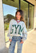 Two moods, one cozy pullover. This reversible mock neck sweater gives you options with light gray on one side and soft white fleece on the other. Printed in hunter green, one side reads “Gym” while the reverse says “Bed,” letting you wear your vibe for the day. With its oversized fit and cozy texture, it’s the perfect piece for lounging, layering, or heading out in casual comfort.