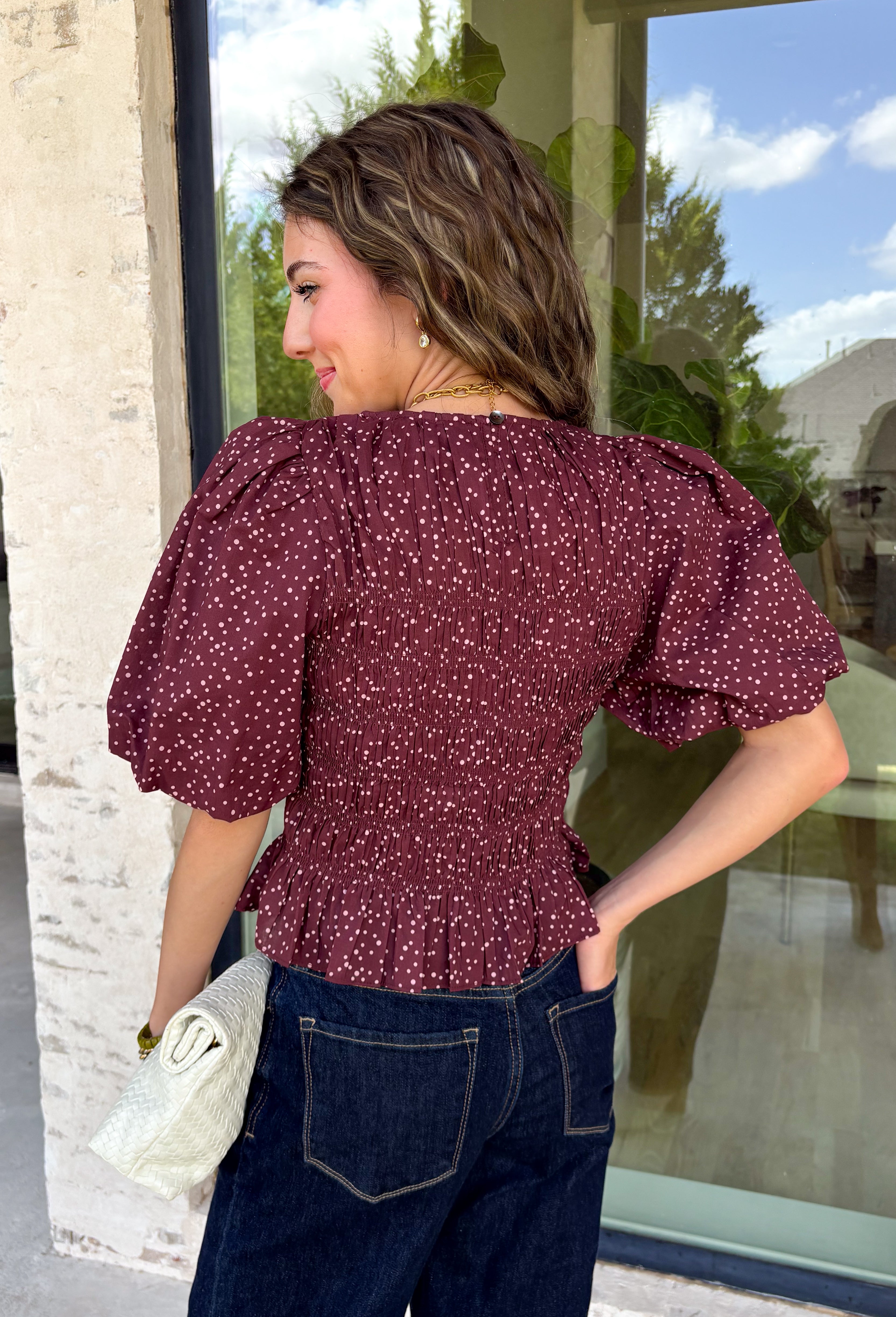 Add a playful touch to your fall wardrobe with this charming top from Entro. Designed in a rich plum hue with a light pink polka dot print, this feminine blouse is both timeless and fun. The smocked bodice creates a flattering, comfortable fit, while the puff sleeves add the perfect touch of romantic charm. Crafted from breathable cotton, this versatile top is easy to dress up for work or pair with denim for an effortless everyday look.