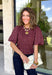 Add a playful touch to your fall wardrobe with this charming top from Entro. Designed in a rich plum hue with a light pink polka dot print, this feminine blouse is both timeless and fun. The smocked bodice creates a flattering, comfortable fit, while the puff sleeves add the perfect touch of romantic charm. Crafted from breathable cotton, this versatile top is easy to dress up for work or pair with denim for an effortless everyday look.