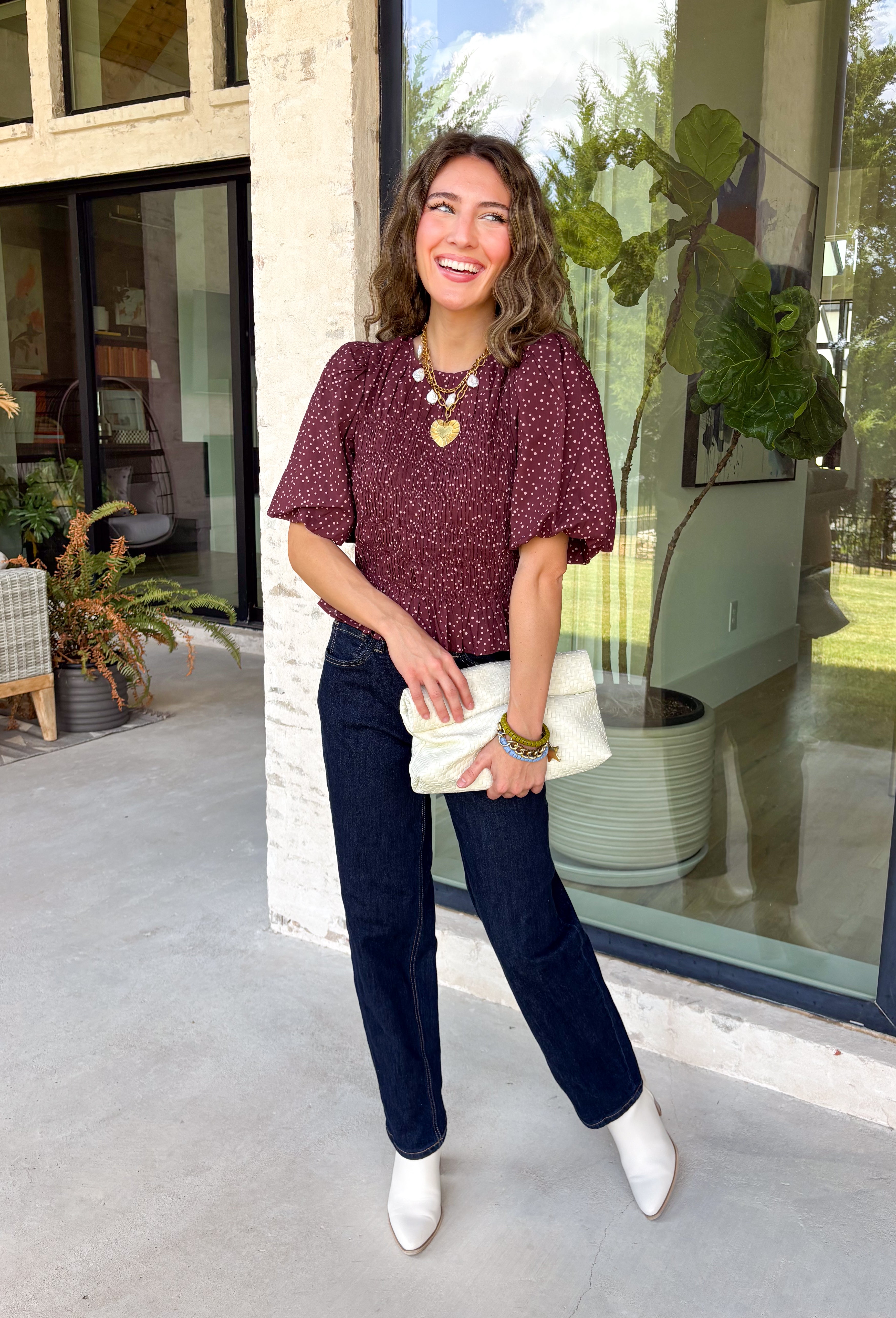 Add a playful touch to your fall wardrobe with this charming top from Entro. Designed in a rich plum hue with a light pink polka dot print, this feminine blouse is both timeless and fun. The smocked bodice creates a flattering, comfortable fit, while the puff sleeves add the perfect touch of romantic charm. Crafted from breathable cotton, this versatile top is easy to dress up for work or pair with denim for an effortless everyday look.