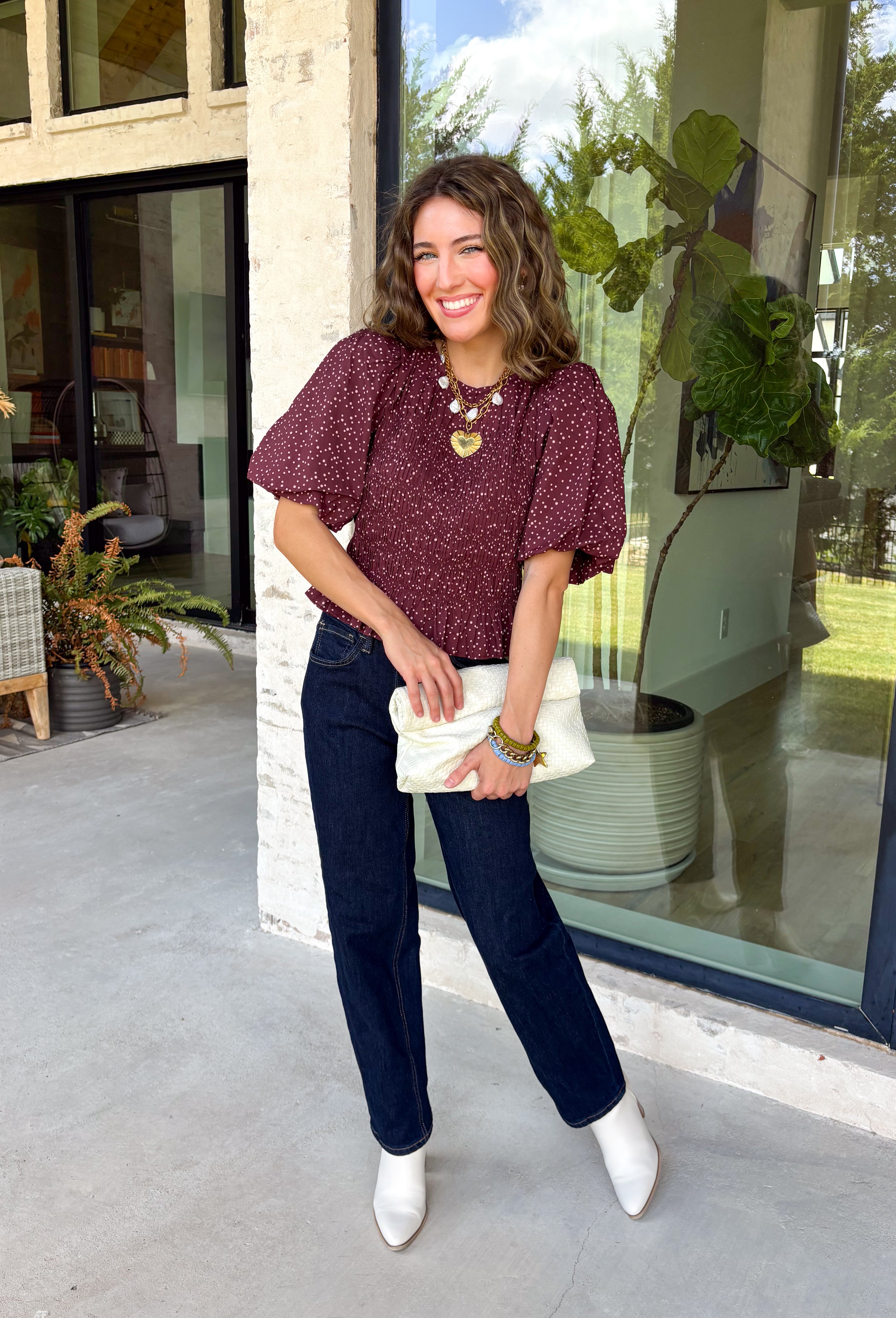 Add a playful touch to your fall wardrobe with this charming top from Entro. Designed in a rich plum hue with a light pink polka dot print, this feminine blouse is both timeless and fun. The smocked bodice creates a flattering, comfortable fit, while the puff sleeves add the perfect touch of romantic charm. Crafted from breathable cotton, this versatile top is easy to dress up for work or pair with denim for an effortless everyday look.