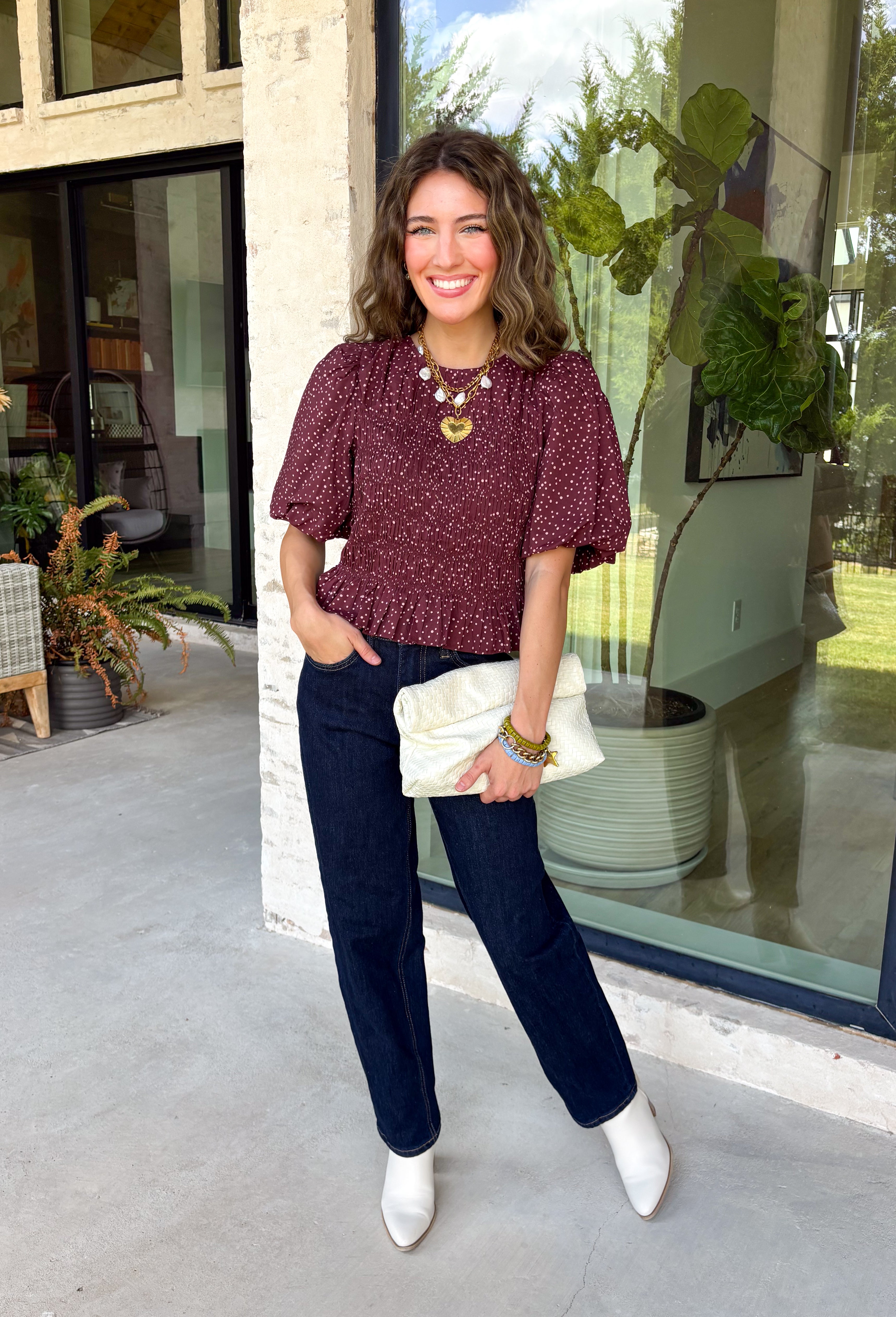 Add a playful touch to your fall wardrobe with this charming top from Entro. Designed in a rich plum hue with a light pink polka dot print, this feminine blouse is both timeless and fun. The smocked bodice creates a flattering, comfortable fit, while the puff sleeves add the perfect touch of romantic charm. Crafted from breathable cotton, this versatile top is easy to dress up for work or pair with denim for an effortless everyday look.