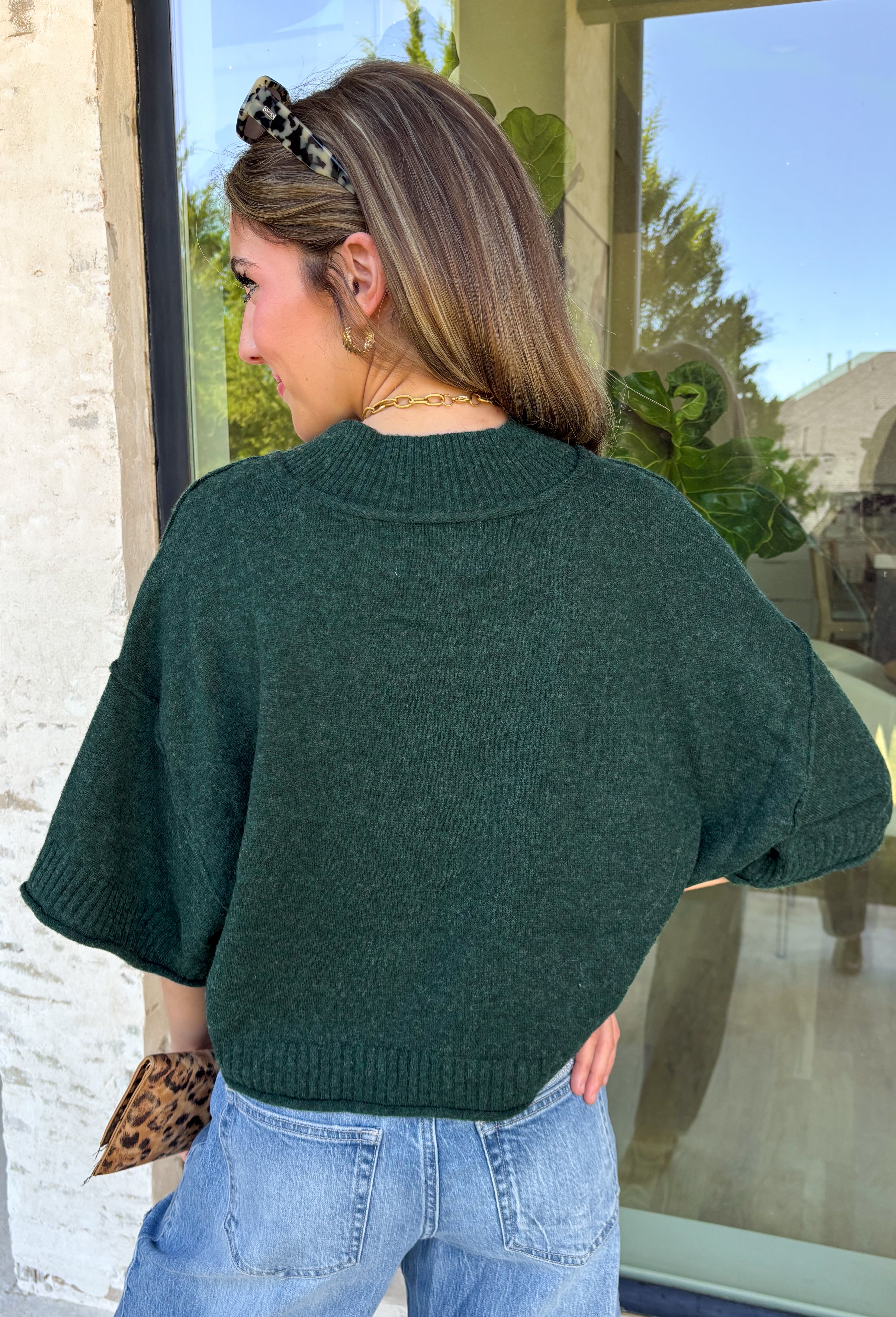 Cozy with a modern edge, this forest green sweater is an easy go-to for cooler days. Designed with a mock neck and cropped length, it’s finished with exposed seam details that add a casual, laid-back vibe. Ribbed cuffs and hem bring structure to the soft knit, while the lightweight blend makes it perfect for layering. A versatile piece that pairs effortlessly with denim, skirts, or wide-leg pants for fall.