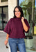 Rich wine color meets cozy knit texture in this short sleeve sweater from &amp; Merci. The deep seasonal shade makes it an easy way to add a little color to your cooler-weather wardrobe while still pairing beautifully with denim and neutral bottoms. A mock neckline gives it a classic finish, while exposed hems add a relaxed, lived-in touch. Ribbed detailing along the neckline, sleeve cuffs, and hem completes the look and adds extra texture throughout. 