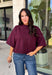 Rich wine color meets cozy knit texture in this short sleeve sweater from &amp; Merci. The deep seasonal shade makes it an easy way to add a little color to your cooler-weather wardrobe while still pairing beautifully with denim and neutral bottoms. A mock neckline gives it a classic finish, while exposed hems add a relaxed, lived-in touch. Ribbed detailing along the neckline, sleeve cuffs, and hem completes the look and adds extra texture throughout. 