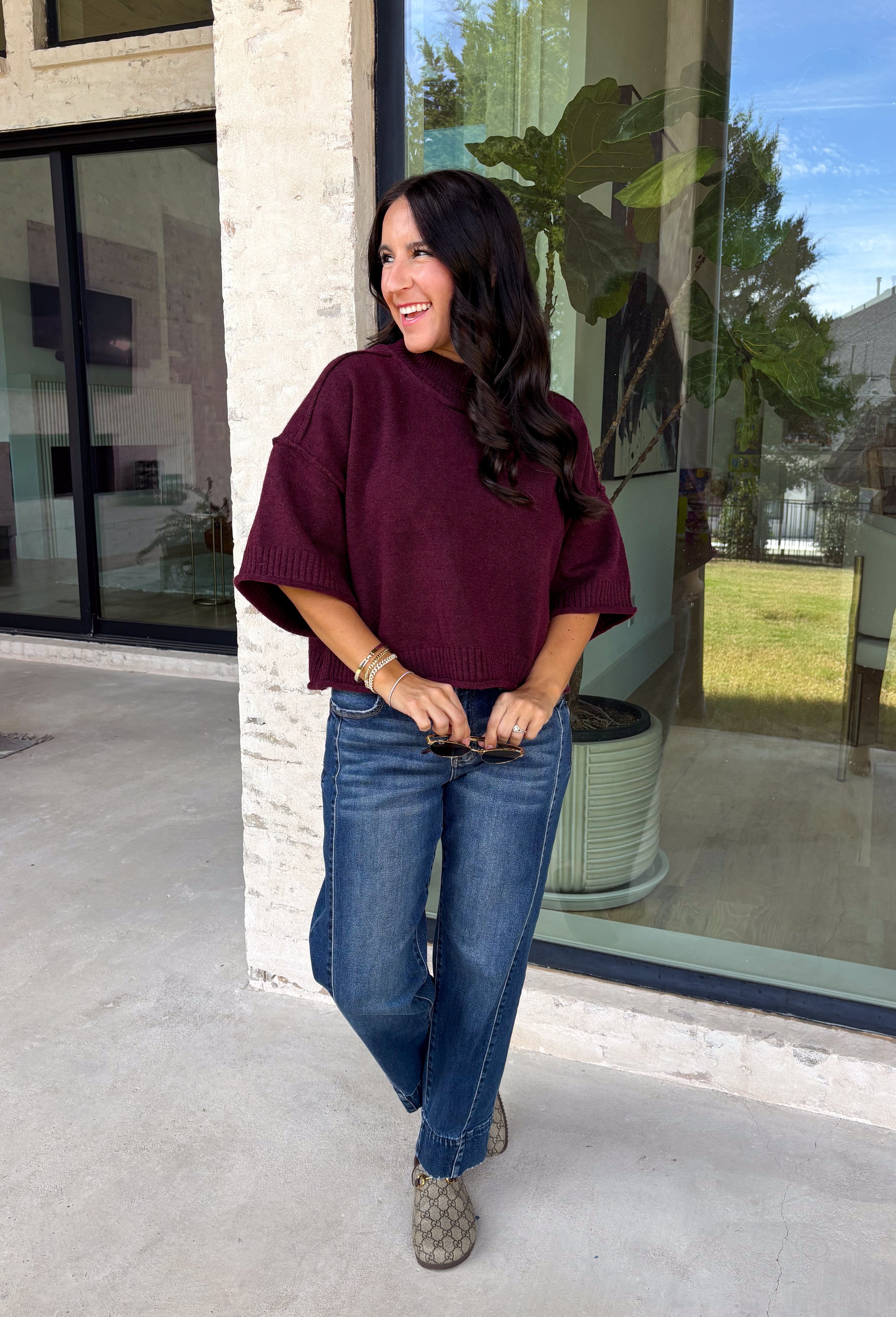 Rich wine color meets cozy knit texture in this short sleeve sweater from &amp; Merci. The deep seasonal shade makes it an easy way to add a little color to your cooler-weather wardrobe while still pairing beautifully with denim and neutral bottoms. A mock neckline gives it a classic finish, while exposed hems add a relaxed, lived-in touch. Ribbed detailing along the neckline, sleeve cuffs, and hem completes the look and adds extra texture throughout. 