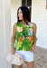 This sleeveless tropical print top is bringing all the vacation-ready energy! With its mix of green palm leaves and vibrant floral tones in blue, pink, orange, and white, it’s the kind of piece that instantly brightens your outfit. The open back detail adds a fun, unexpected twist that feels perfect for warm summer days and nights. Lightweight and breezy, it pairs effortlessly with denim shorts, white jeans, or a flowy skirt. 