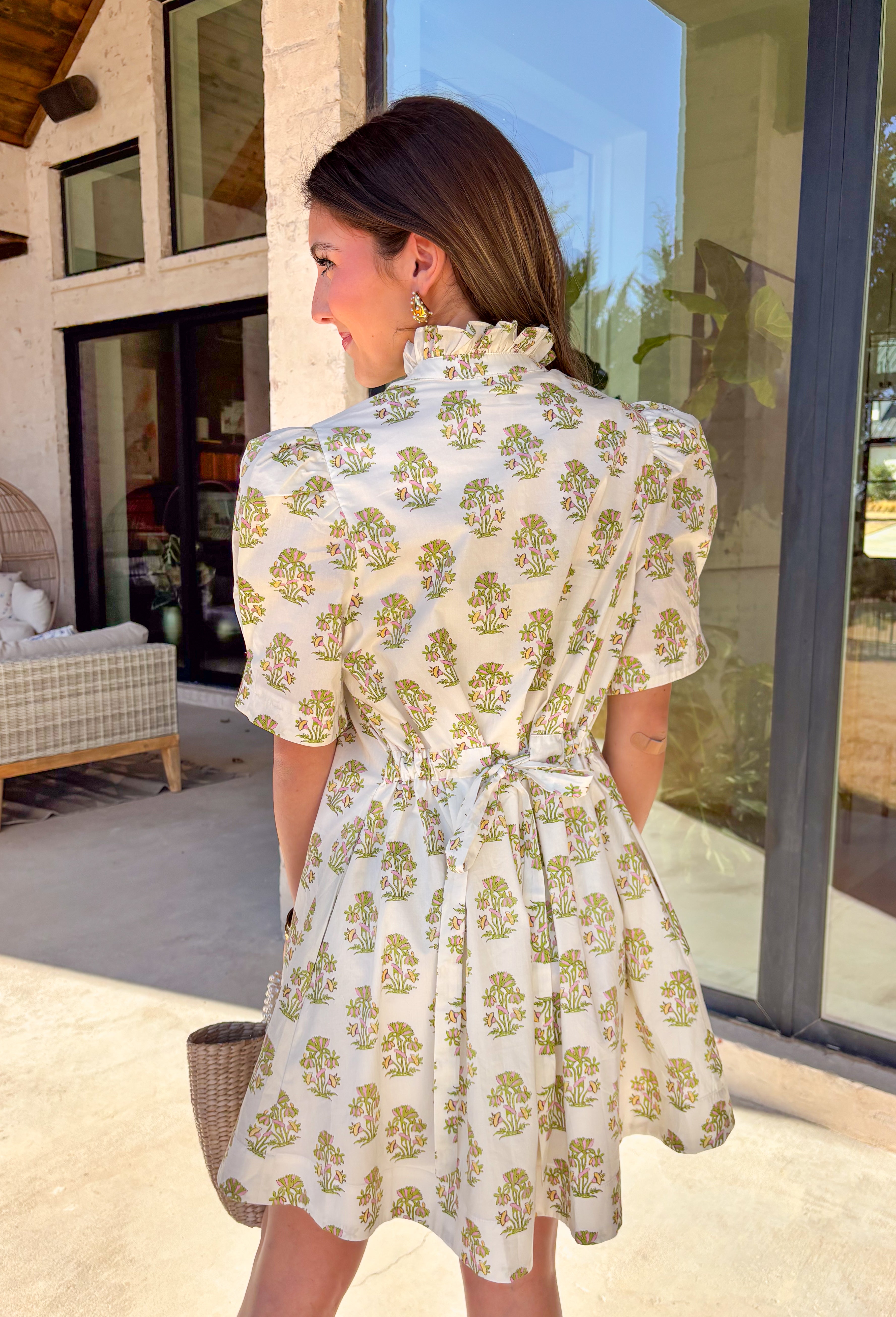 Sweet, soft, and perfect for spring days, this cream short sleeve dress is full of easy charm. Featuring a delicate green and pink floral print throughout, it feels light, fresh, and effortlessly pretty. The subtle ruffle neckline and puff sleeves add a feminine touch, while the front button details keep the look classic and wearable. Fully lined and made from breathable cotton, this is the kind of dress you’ll reach for on sunny days, brunch plans, and spring events.