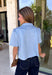 Give your everyday wardrobe a fresh update with this beautifully crafted faux suede top from Day + Moon. Designed in a soft light blue hue, this elevated button-down features a feminine scalloped collar that adds the perfect touch of charm. The short cuffed sleeves and classic button-front design create a polished silhouette that's easy to style for any occasion. 