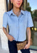 Give your everyday wardrobe a fresh update with this beautifully crafted faux suede top from Day + Moon. Designed in a soft light blue hue, this elevated button-down features a feminine scalloped collar that adds the perfect touch of charm. The short cuffed sleeves and classic button-front design create a polished silhouette that's easy to style for any occasion. 