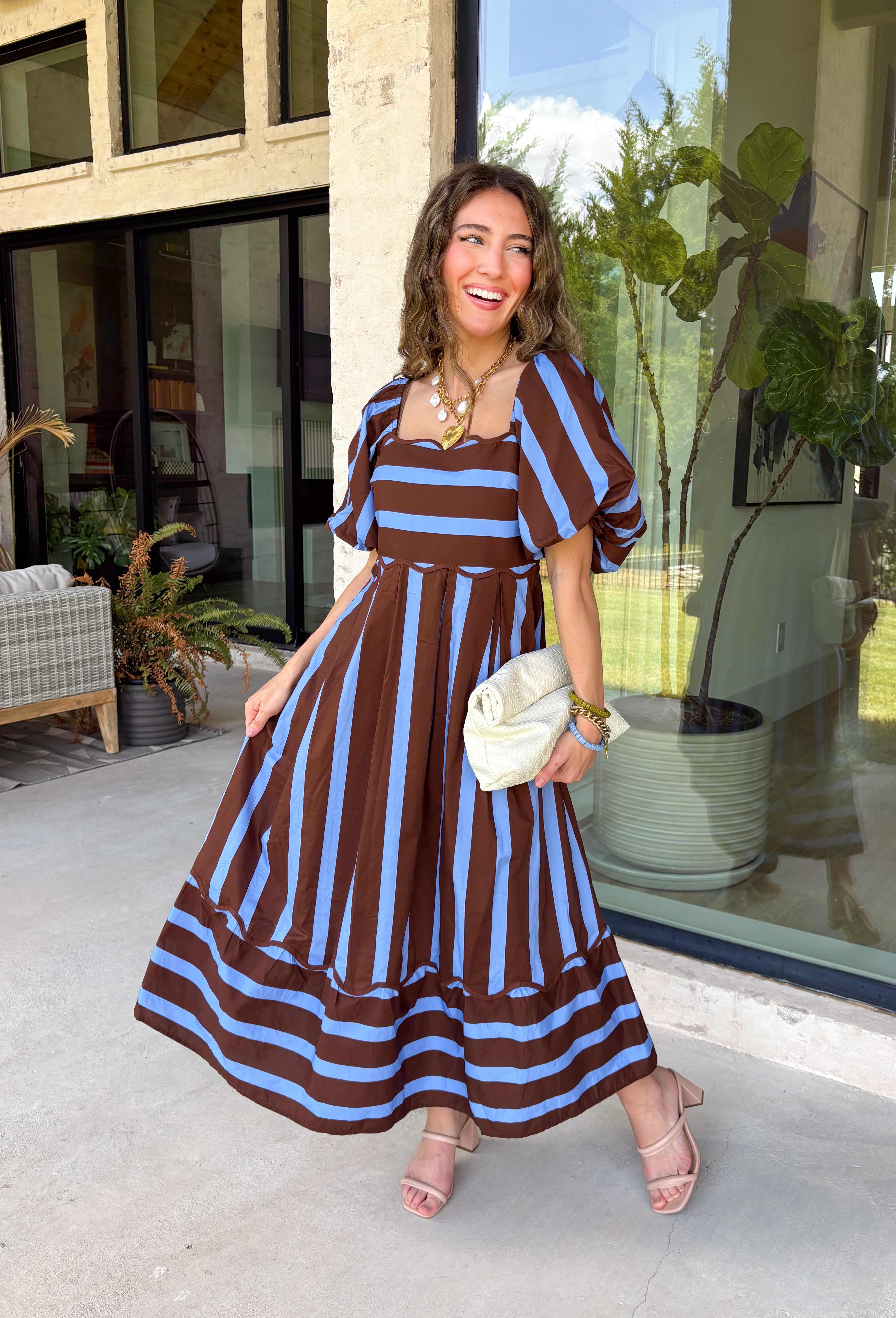 Brown and blue come together in the prettiest way on this striped midi dress from Entro. The scalloped square neckline gives the classic stripe print a sweet, unexpected touch, while short puff sleeves add just the right amount of shape. A smocked back creates a comfortable fit that moves with you, and convenient side pockets make this one even easier to love. 