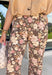 Give your fall wardrobe a fresh update with these beautifully printed floral pants. Featuring a rich brown backdrop with a bold neutral floral print, these statement pants are the perfect blend of timeless and trendy. Front seam detailing creates a flattering, elongated silhouette, while the classic zip-fly, button closure, and belt loops make them easy to style with all your favorite seasonal tops and sweaters. 