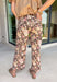 Give your fall wardrobe a fresh update with these beautifully printed floral pants. Featuring a rich brown backdrop with a bold neutral floral print, these statement pants are the perfect blend of timeless and trendy. Front seam detailing creates a flattering, elongated silhouette, while the classic zip-fly, button closure, and belt loops make them easy to style with all your favorite seasonal tops and sweaters. 