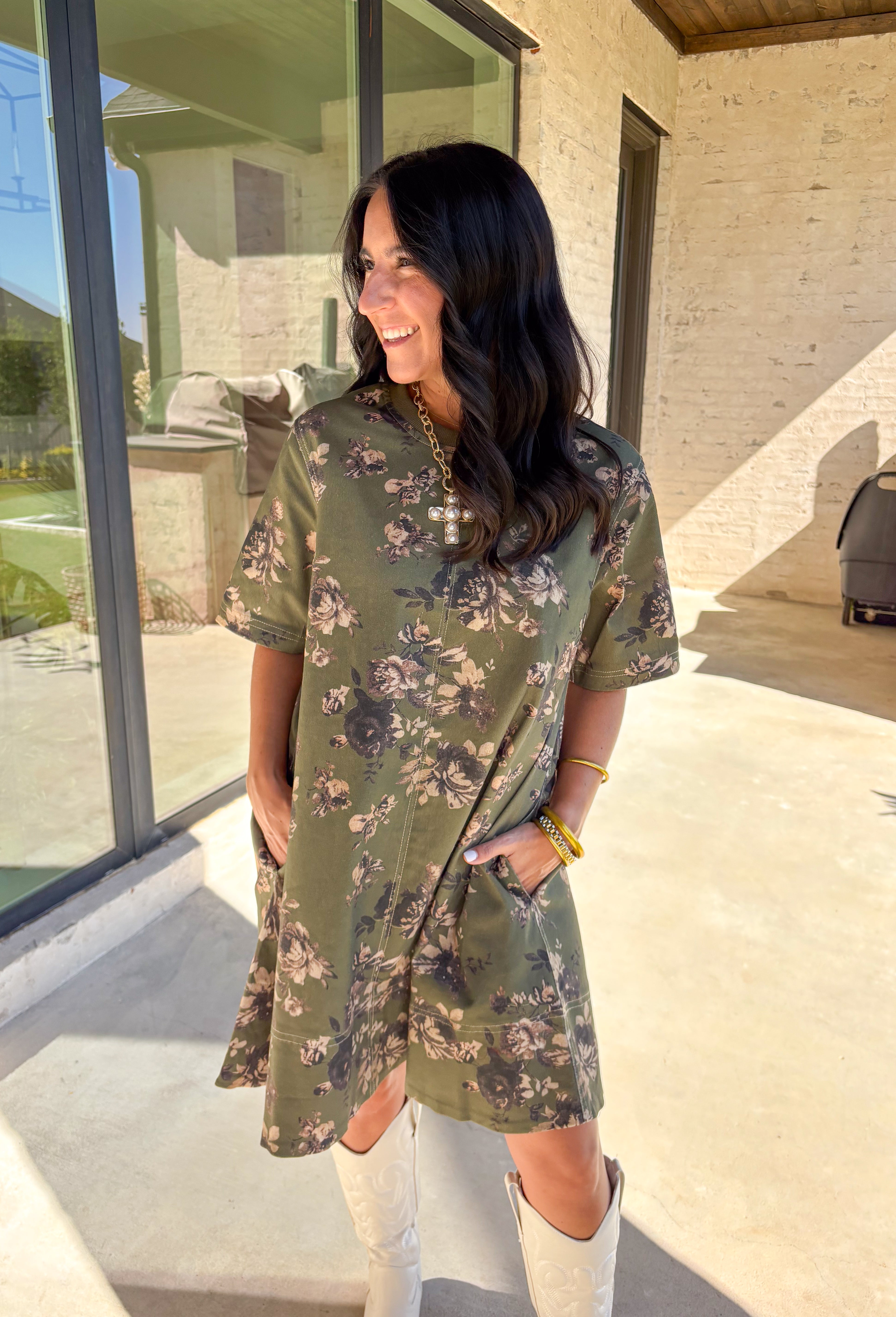 This olive green short sleeve dress by Entro brings an effortless mix of comfort and charm to your fall wardrobe. The neutral floral print adds a soft, seasonal touch, while the relaxed silhouette makes it easy to wear for any occasion. Fully lined with convenient side pockets, this dress is the perfect throw-on-and-go piece for the season—simple, flattering, and endlessly versatile.