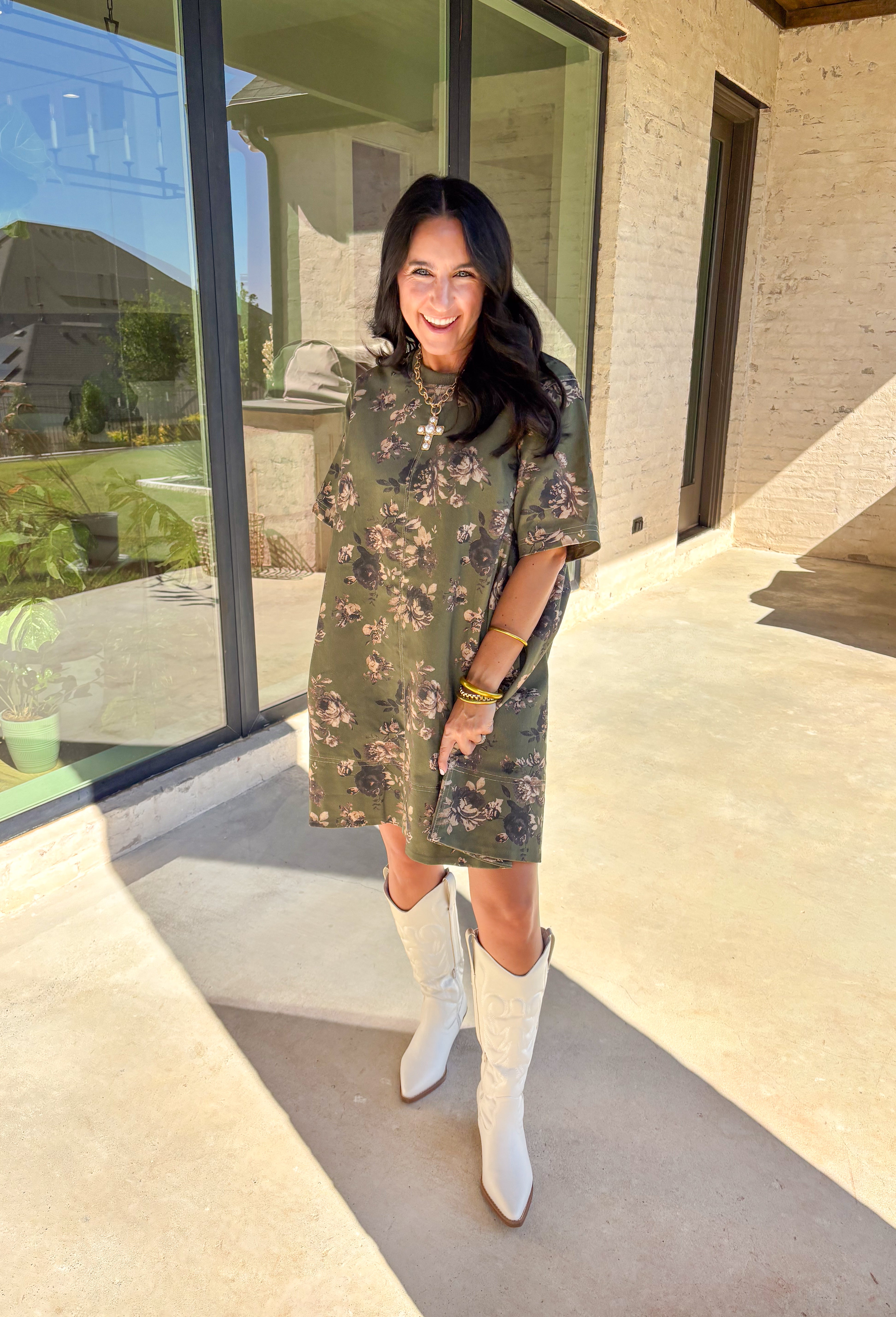 This olive green short sleeve dress by Entro brings an effortless mix of comfort and charm to your fall wardrobe. The neutral floral print adds a soft, seasonal touch, while the relaxed silhouette makes it easy to wear for any occasion. Fully lined with convenient side pockets, this dress is the perfect throw-on-and-go piece for the season—simple, flattering, and endlessly versatile.