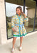 Fresh, bright, and effortlessly polished, this neutral long sleeve button-down dress is made for spring days when you want to feel put together without trying too hard. Featuring a yellow and blue floral print with pops of green, it brings the prettiest burst of color to a soft neutral base. Blue and green band detailing along the neckline and down the front adds a bold, flattering accent, with matching trim at the cuffs and hem for a pulled-together finish. 