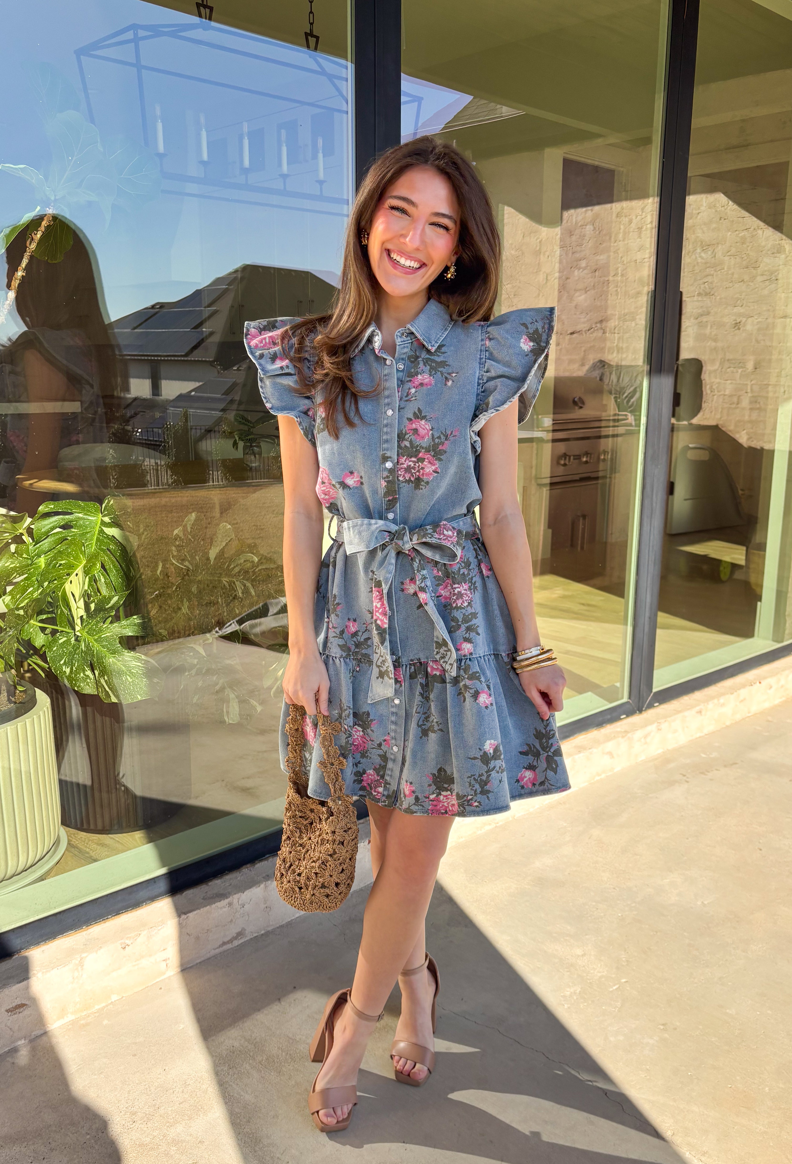 Denim, but make it spring! This short sleeve button-down denim dress by Entro is the cutest mix of classic and playful, featuring a pink floral print that instantly brightens up your look. The collared neckline and button-down front keep it polished, while the tiered skirt adds an easy, feminine flow. Finished with a matching self-tie belt to cinch the waist just right, this dress is perfect for brunch, spring events, or any day you want an effortless outfit that still feels special.