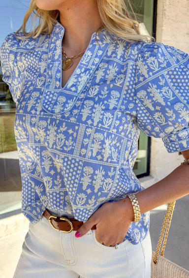 Fresh, pretty, and perfect for spring, this light blue top by Entro is an effortless favorite. Featuring an off-white patchwork floral print throughout, it brings a soft, charming vibe that’s easy to dress up or keep casual. Puff sleeves add a sweet, feminine touch, while the breathable cotton fabric keeps it lightweight and comfortable for warmer days ahead. This is one of those tops that instantly makes your outfit feel pulled together—without even trying.