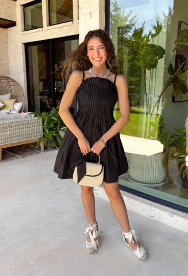 Every closet deserves a timeless little black dress, and this one is sure to become your new favorite! Designed with a flattering straight neckline and chic pleated bodice, this dress offers a polished look that's perfect for any occasion. Adjustable shoulder straps and a smocked back provide a comfortable, customizable fit, while side pockets add the practical detail everyone loves. 