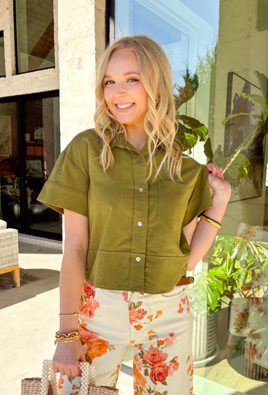Easy, breezy, and effortlessly polished, this olive short sleeve button-down top by Entro is a spring staple you’ll wear on repeat. The ruffle neckline adds a soft, feminine touch to the classic button-down silhouette, while the front pocket detail keeps it casual and everyday-friendly. Made from a breathable cotton-linen blend, this top feels lightweight and airy—perfect for warm spring days, weekend plans, and everything in between.