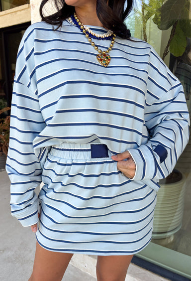Classic stripes get a fresh update with this long sleeve top from Day + Moon. The light blue base is paired with navy and white stripes for a crisp color combination that’s easy to wear throughout the season. Made from a soft cotton blend with a touch of stretch, it keeps you comfortable whether you’re heading to work, running errands, or making weekend plans. 