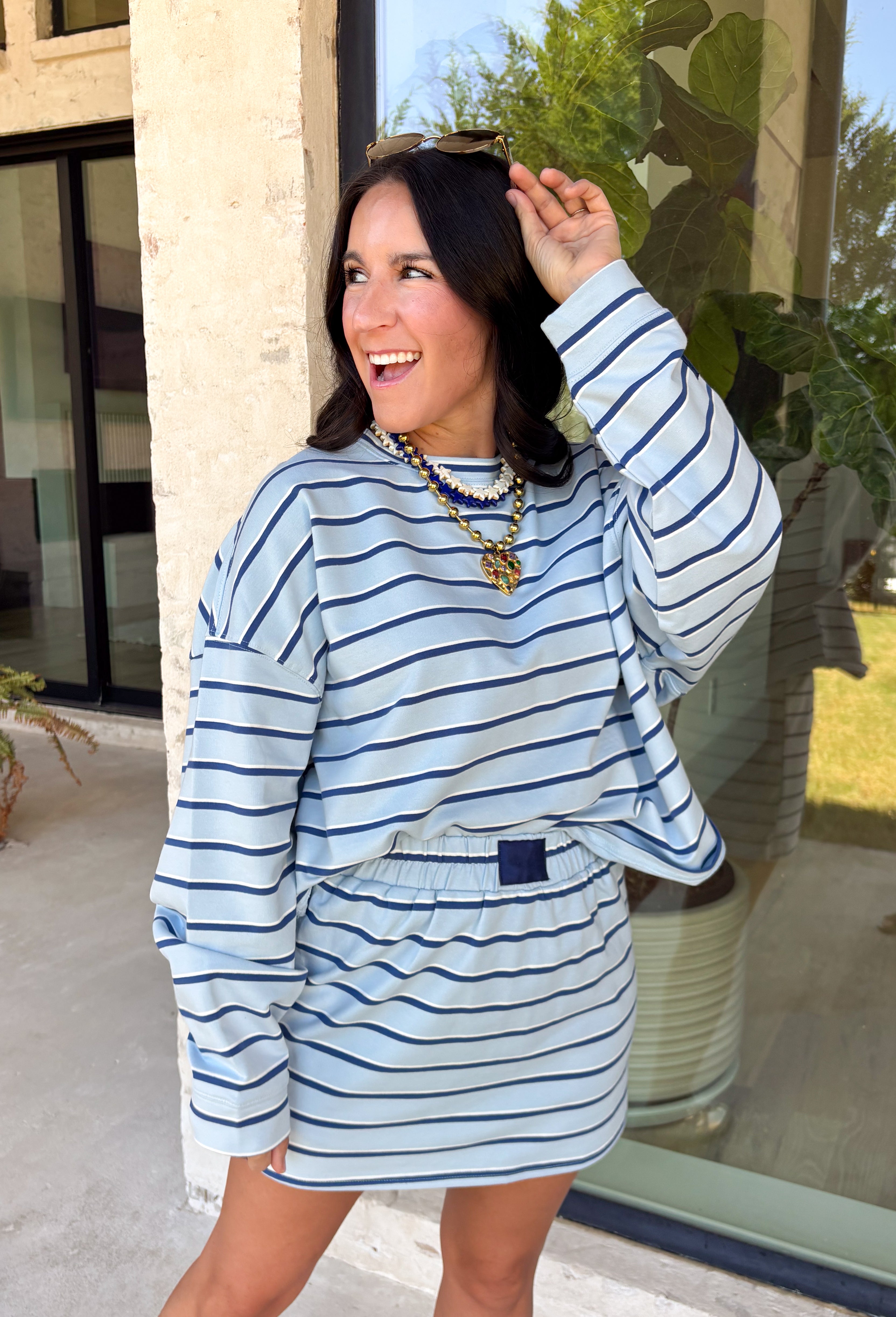 Classic stripes get a fresh update with this long sleeve top from Day + Moon. The light blue base is paired with navy and white stripes for a crisp color combination that’s easy to wear throughout the season. Made from a soft cotton blend with a touch of stretch, it keeps you comfortable whether you’re heading to work, running errands, or making weekend plans. 