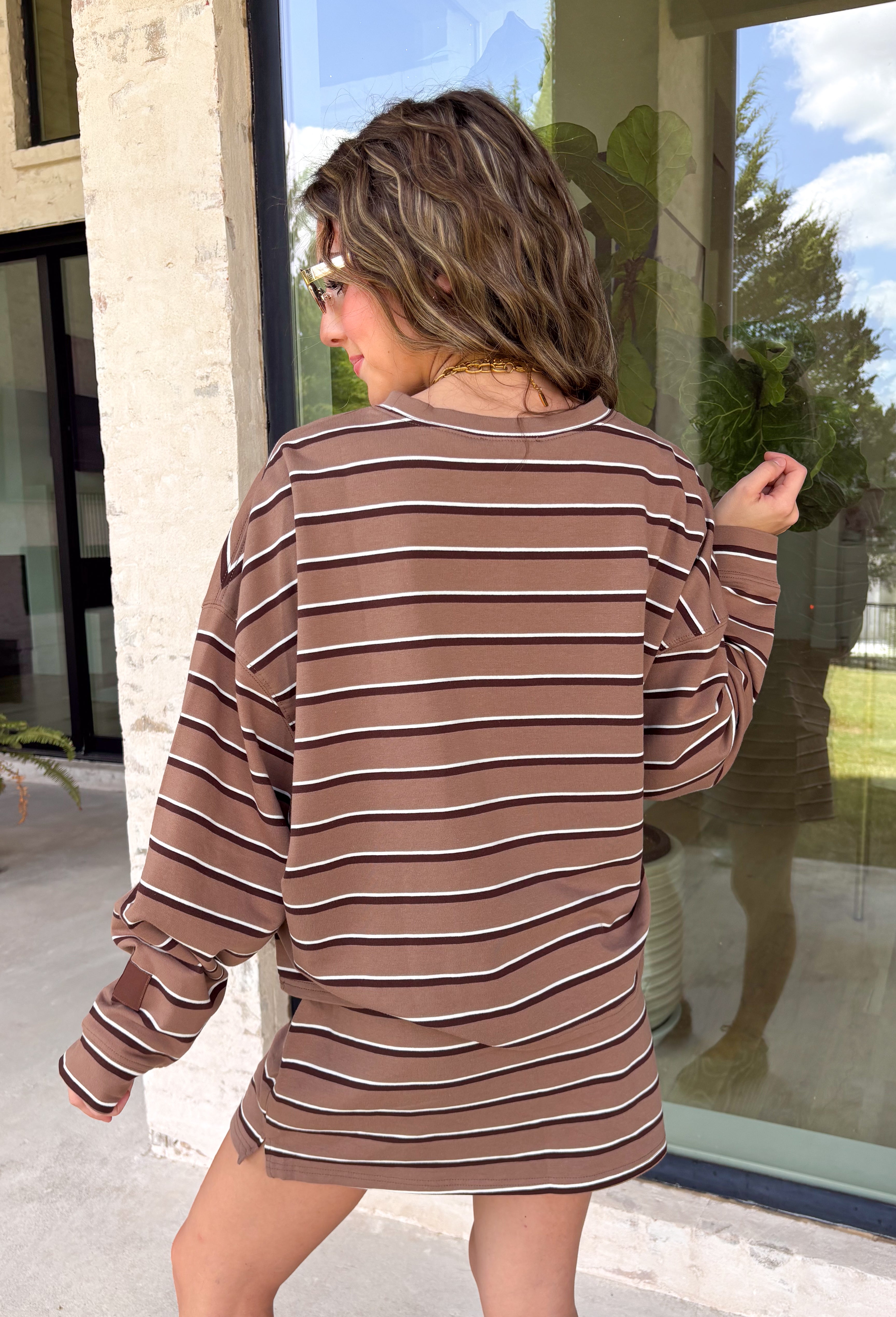 Neutral stripes make this long sleeve top from Day + Moon an easy favorite for the season. The tan base is paired with brown and ivory stripes for a warm color combination that fits right in with your fall wardrobe. Made from a soft cotton blend with a touch of stretch, it offers plenty of comfort for everything from workdays to weekend plans. 