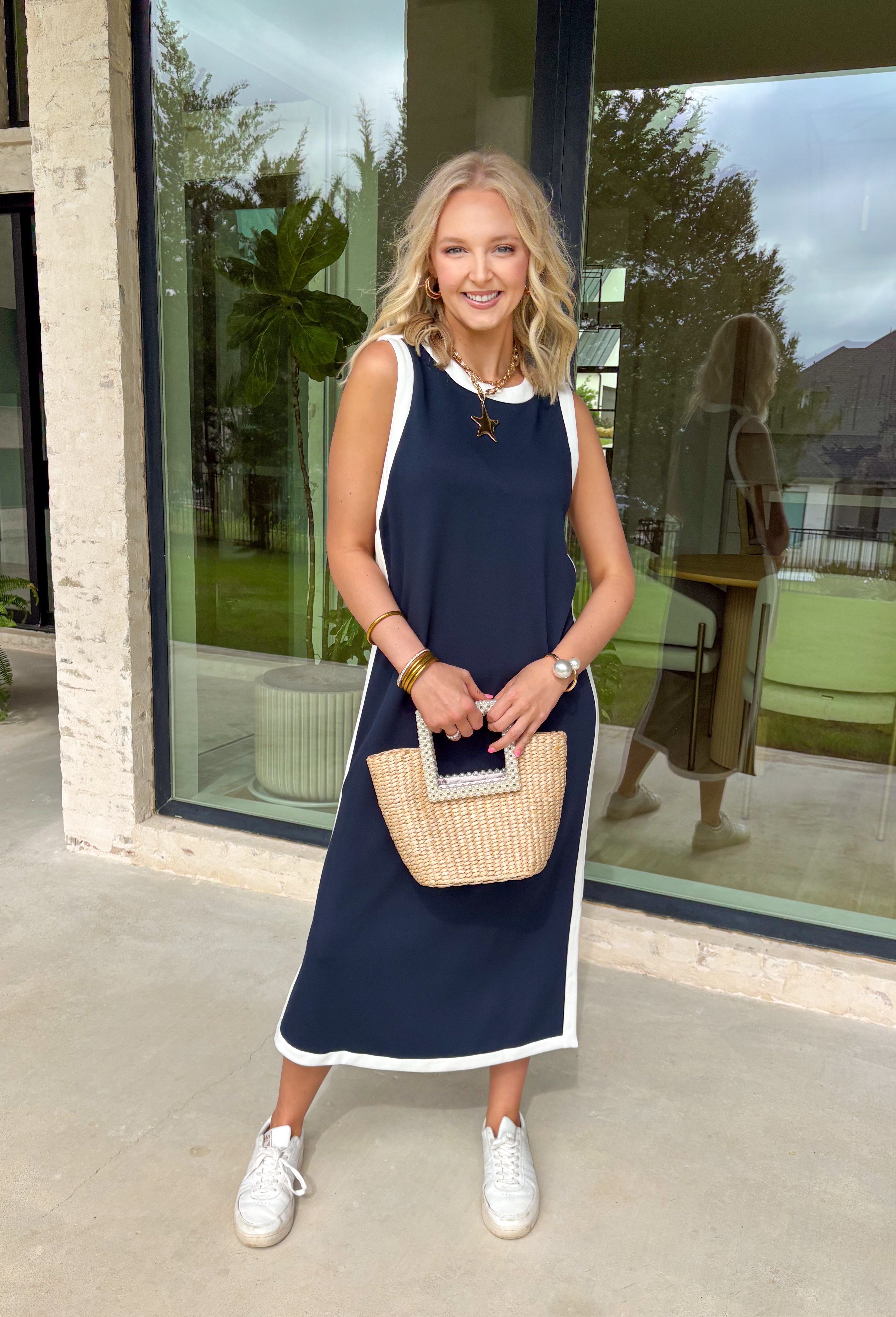 Sleek, simple, and effortlessly chic, this navy sleeveless midi dress by Entro is a fresh spring staple you’ll wear on repeat. Designed with crisp white contrast binding along the neckline, armholes, and hem, it offers a polished look with just the right amount of edge. A side slit adds easy movement, while the lightweight, soft fabric blend keeps it comfortable for warm spring days and breezy evenings.