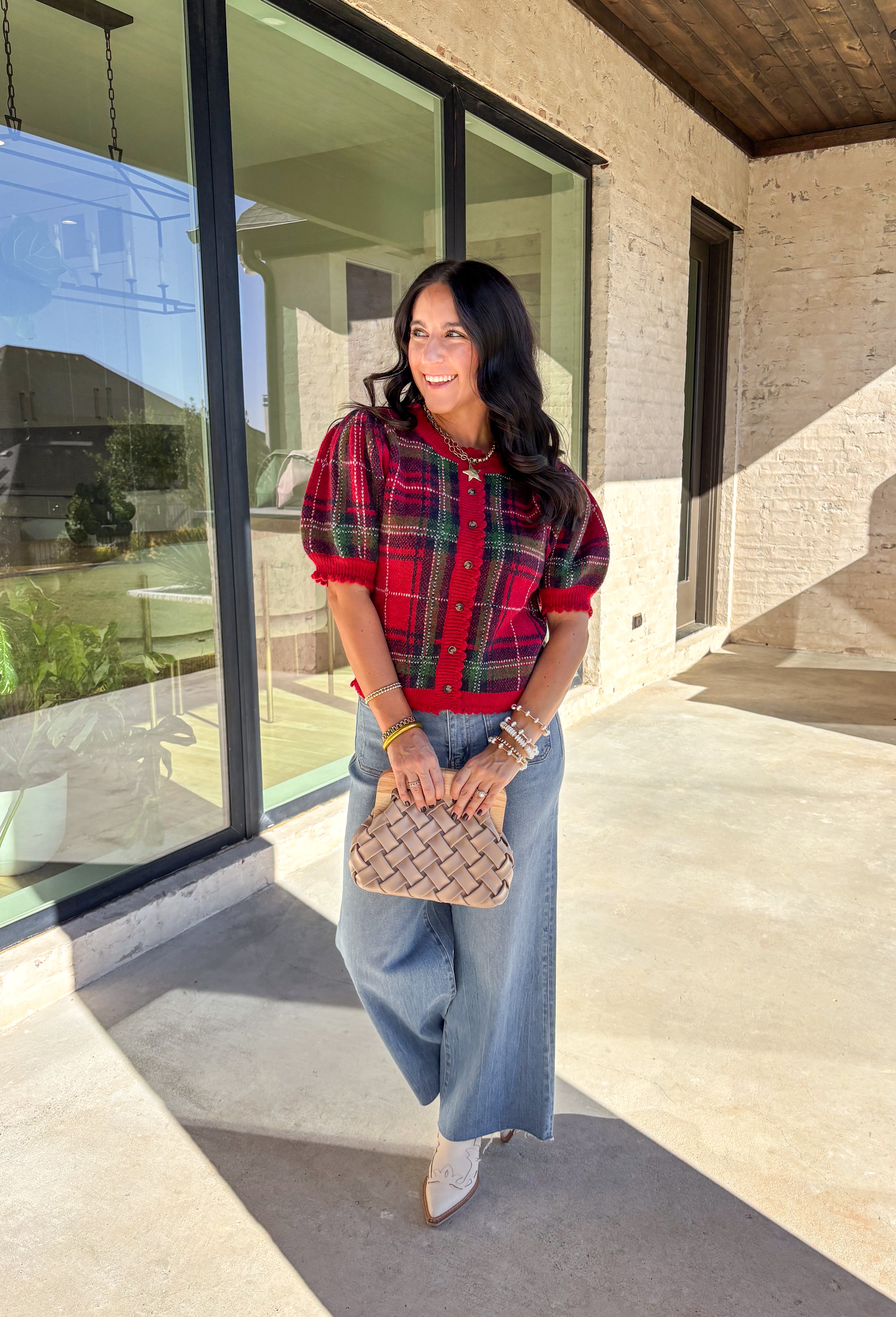 Festive and cozy, this plaid sweater knit top is made to bring holiday cheer. Featuring short puff sleeves and a scallop edge neckline, it’s finished with a button-front closure for a cardigan-style fit. The bold red plaid pattern in holiday tones makes it a standout for seasonal gatherings, while the soft knit keeps it comfortable and easy to wear. Perfect for layering or styling on its own, this cardigan blends playful charm with cozy comfort.
