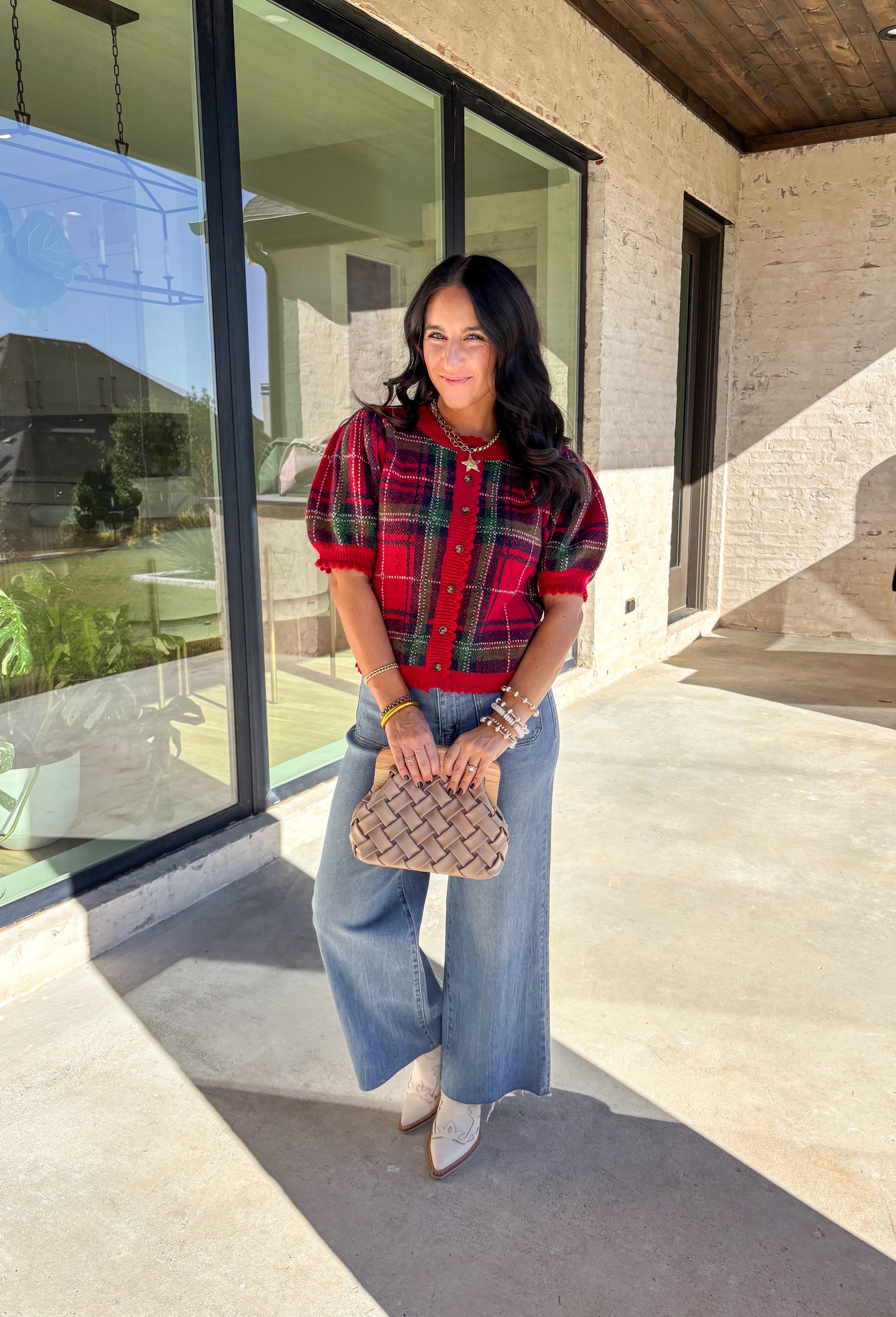 Festive and cozy, this plaid sweater knit top is made to bring holiday cheer. Featuring short puff sleeves and a scallop edge neckline, it’s finished with a button-front closure for a cardigan-style fit. The bold red plaid pattern in holiday tones makes it a standout for seasonal gatherings, while the soft knit keeps it comfortable and easy to wear. Perfect for layering or styling on its own, this cardigan blends playful charm with cozy comfort.