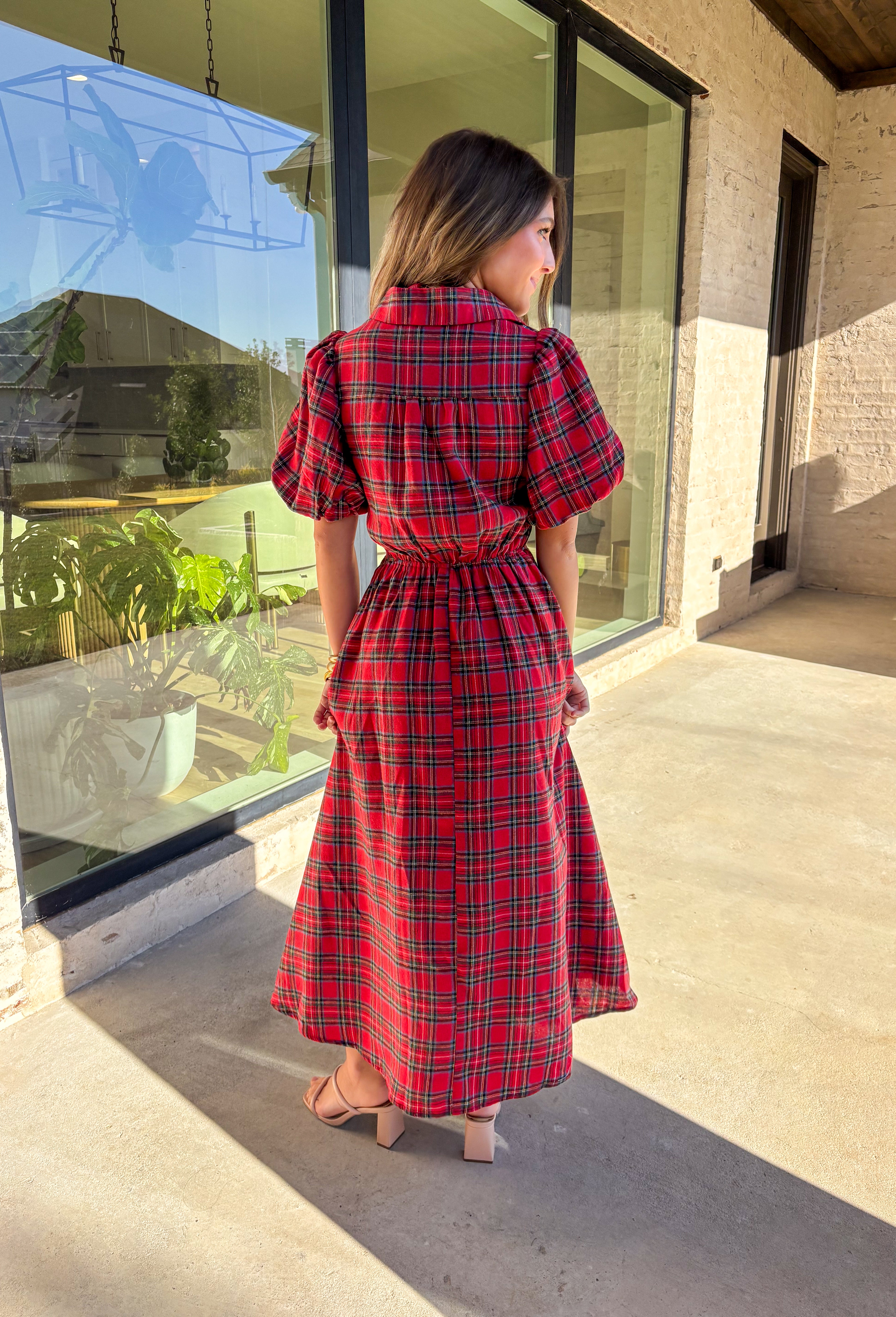 Get ready to celebrate in style with this red plaid midi dress by Entro. Designed with puff sleeves and a button-front closure, it’s both classic and festive. A self-tie waist belt cinches the shape for a flattering fit, while side pockets and a soft lining keep it practical and comfortable. With its cheerful plaid pattern and timeless silhouette, this dress is the perfect choice for holiday gatherings and seasonal events.